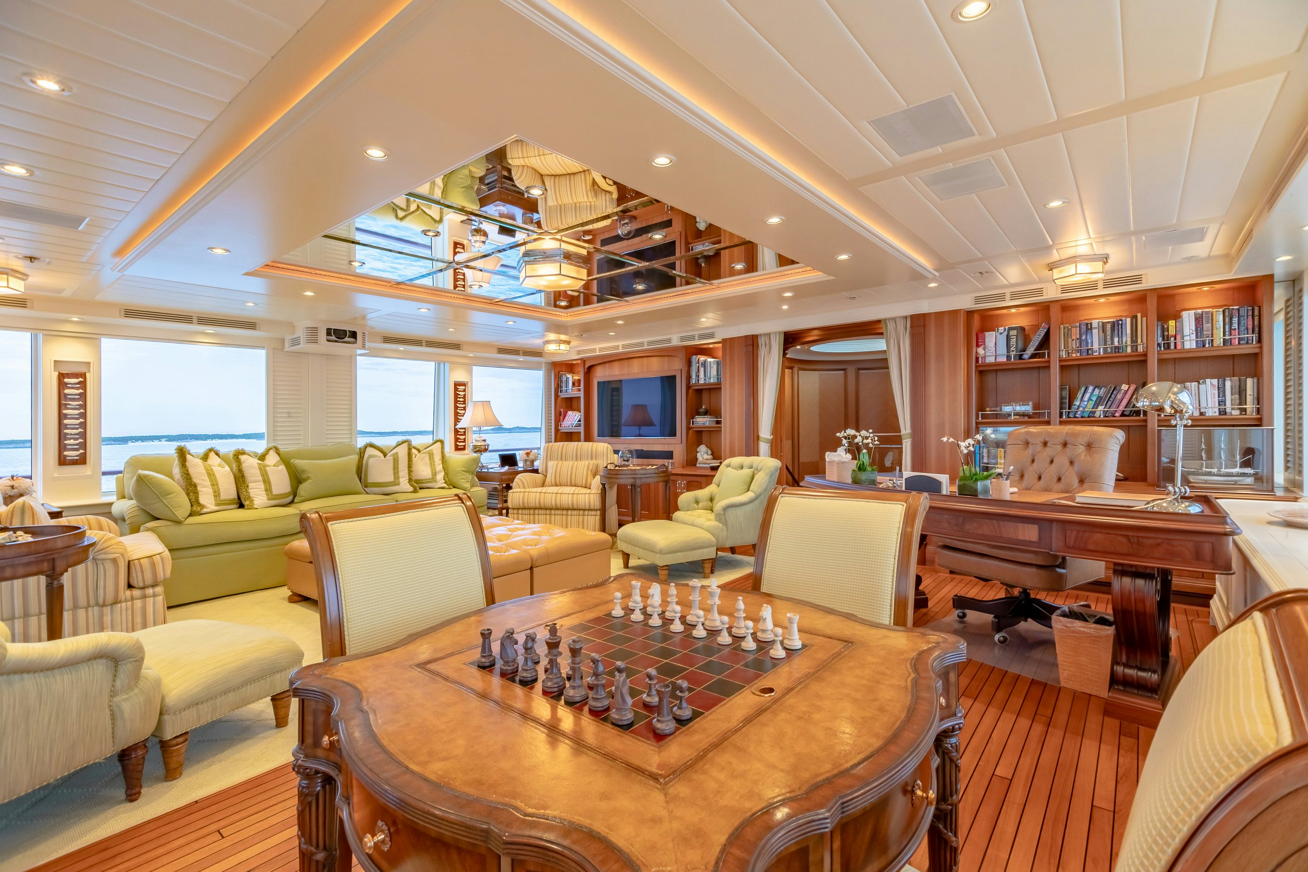 a large living room with a large table and chairs aboard SHADOWL Yacht for Charter