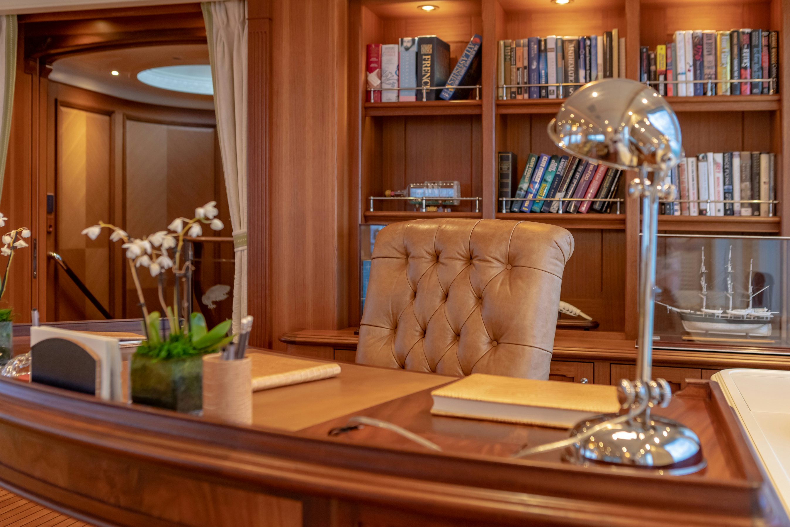 a living room with a coffee table and a book shelf aboard SHADOWL Yacht for Charter