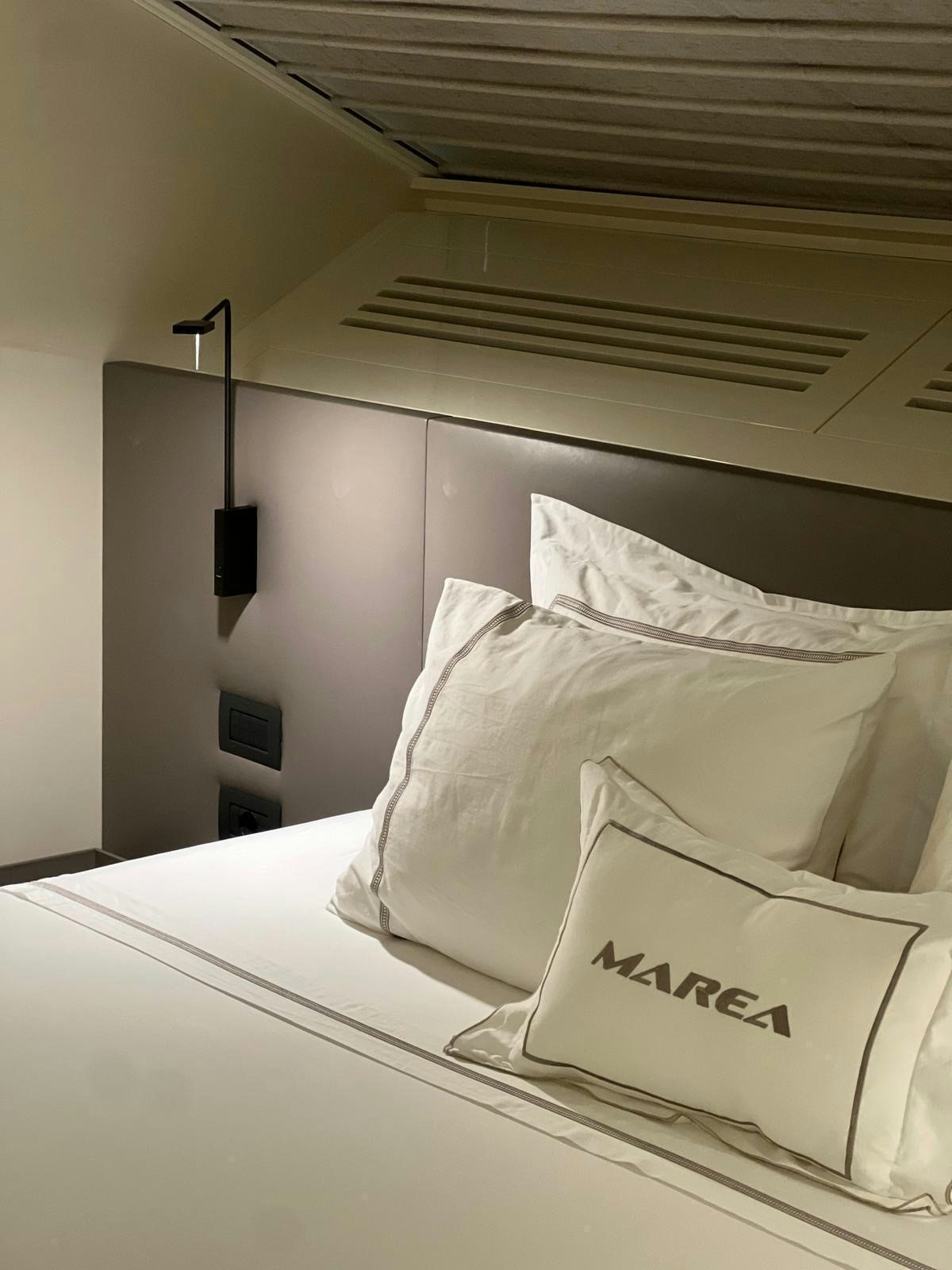 a bed with white sheets aboard MAREA Yacht for Sale