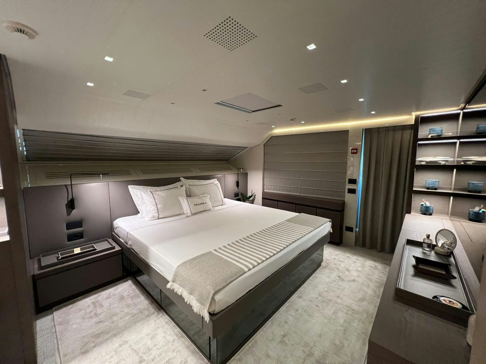 a bedroom with a bed and a desk aboard MAREA Yacht for Sale