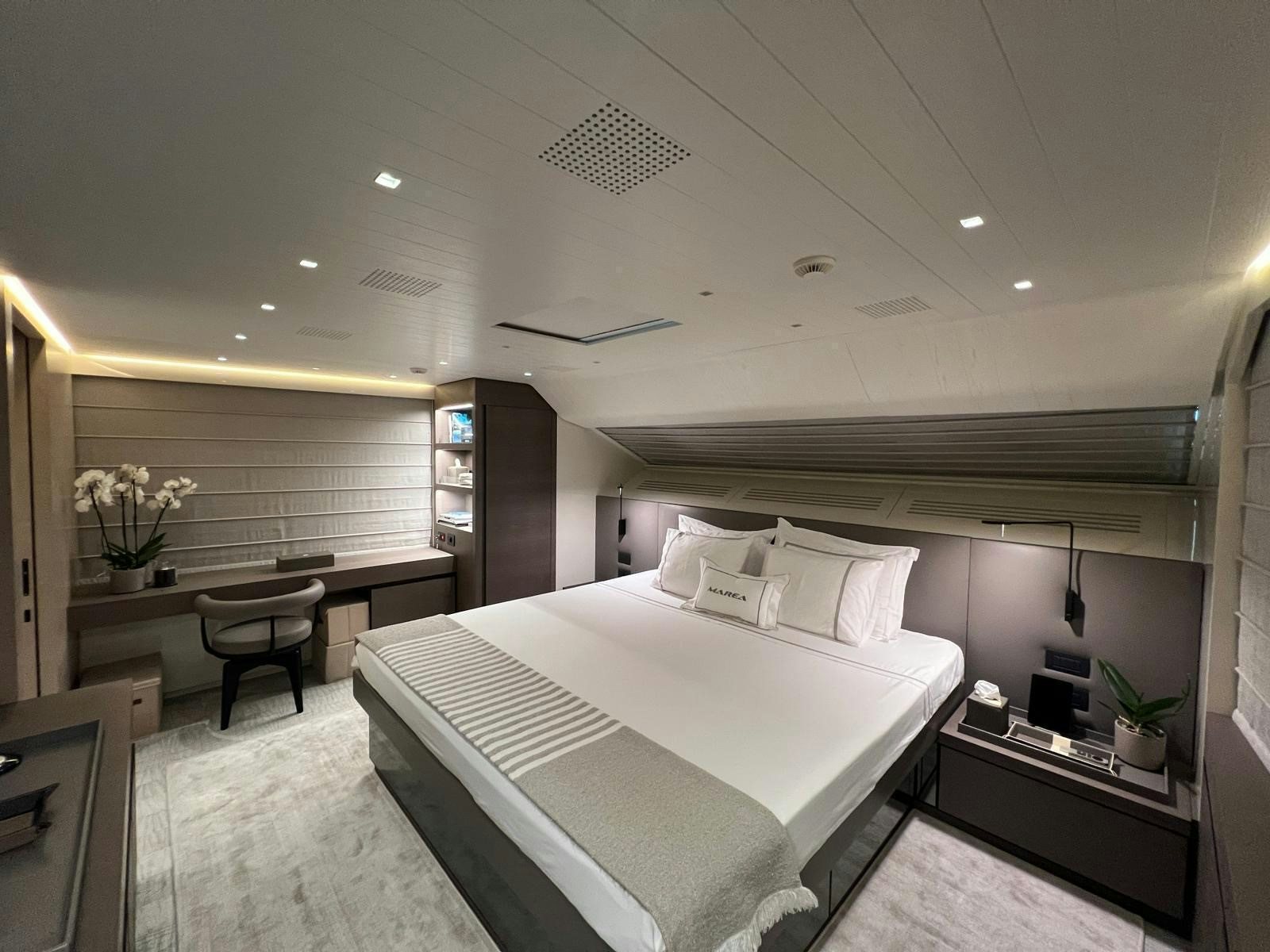 a bedroom with a bed and desk aboard MAREA Yacht for Sale