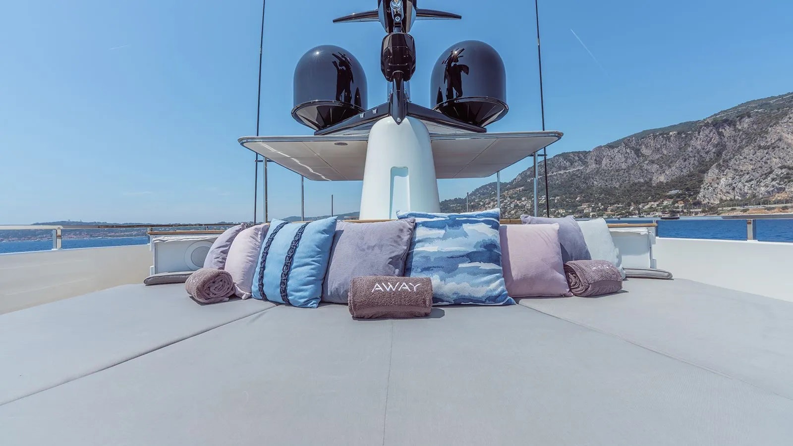 a bed with a white bed spread and a white tent with a white roof and a large fan aboard AWAY Yacht for Charter