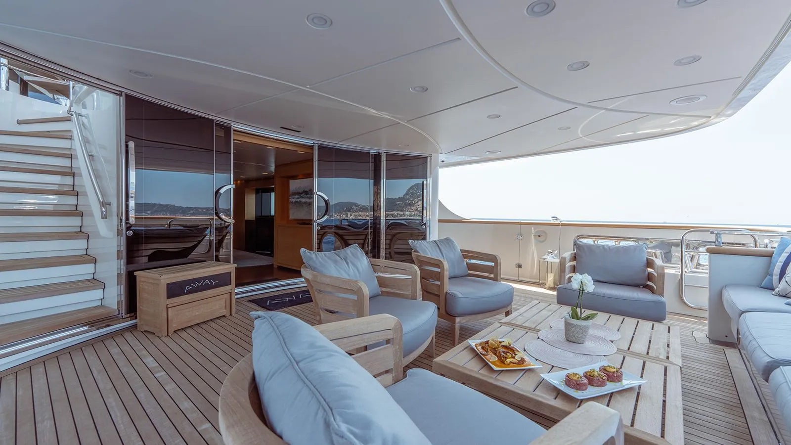 a room with a table chairs and a large window aboard AWAY Yacht for Charter