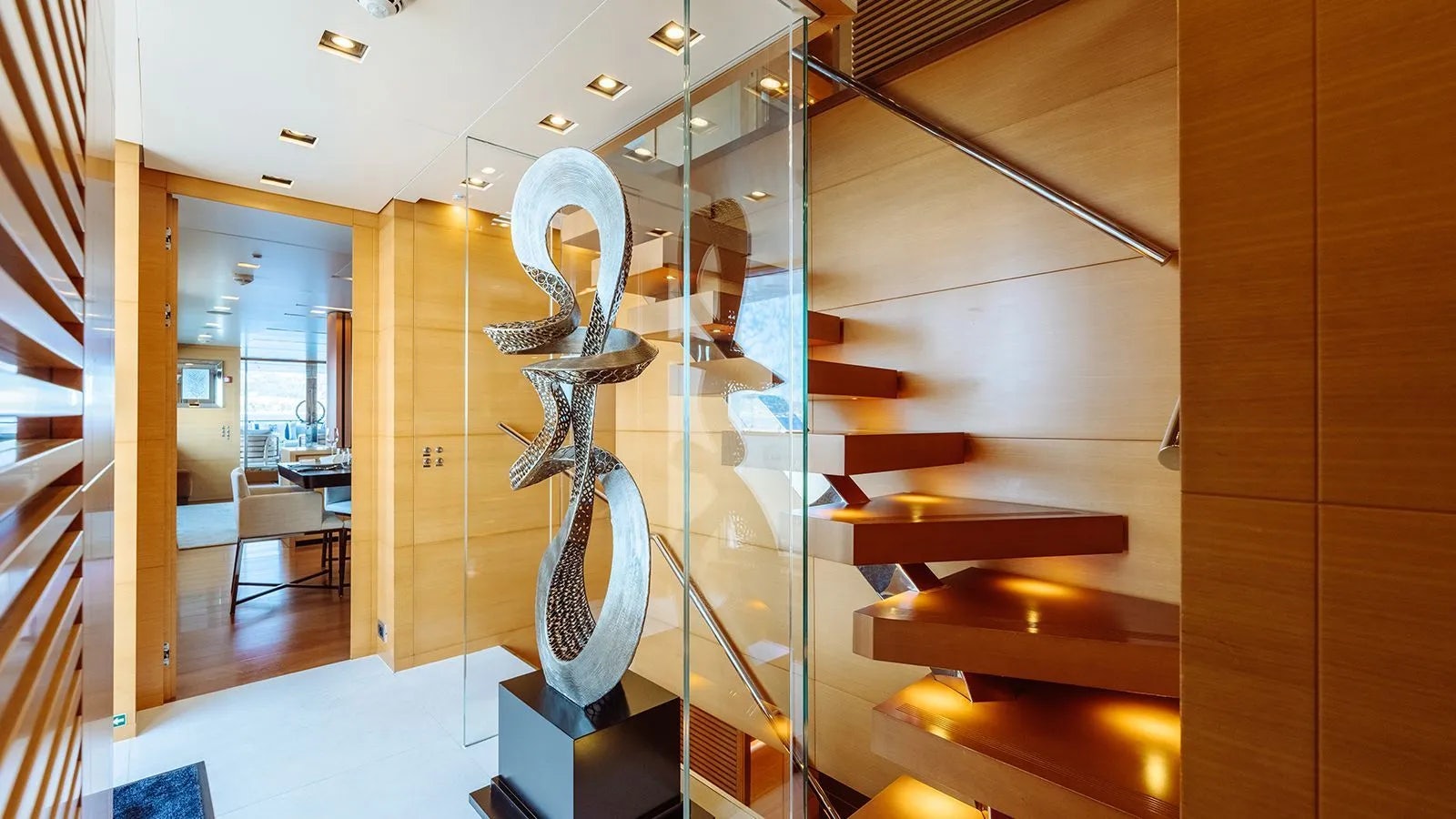 a room with wood stairs and a statue in it aboard AWAY Yacht for Charter
