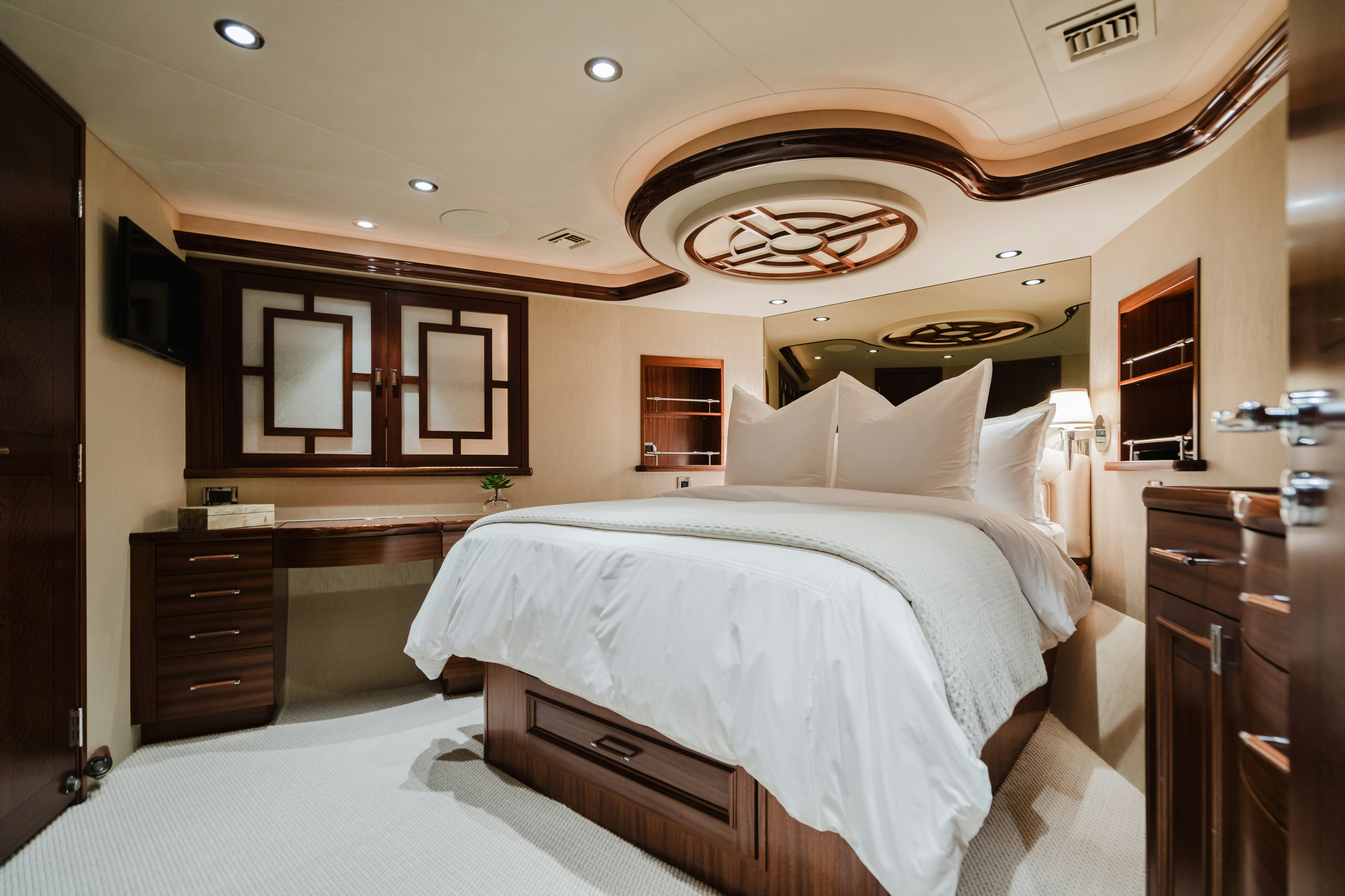 a bedroom with a bed and a dresser aboard SEAQUINN Yacht for Sale