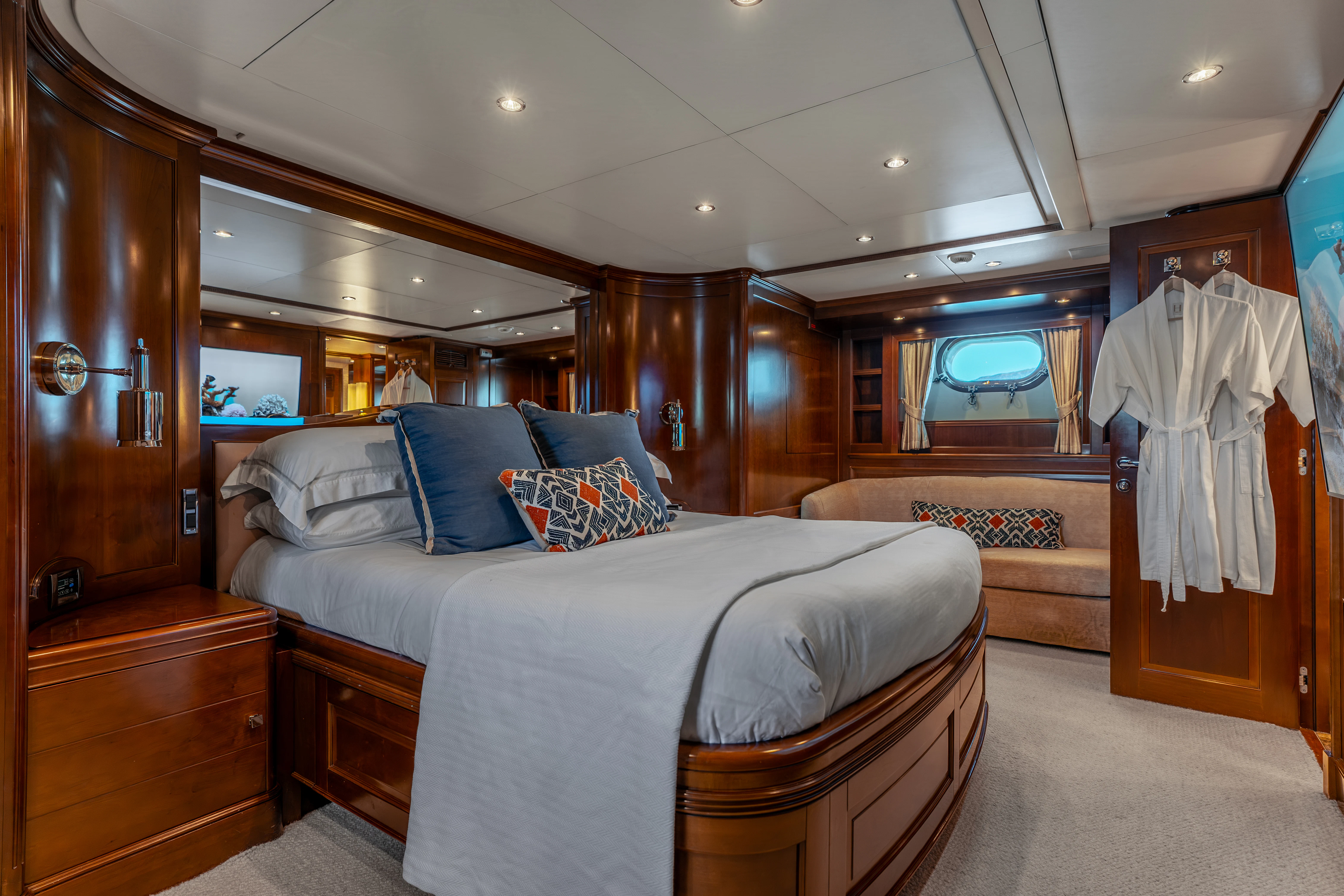 a bedroom with a bed and a wood cabinet aboard ARTEMIS Yacht for Sale