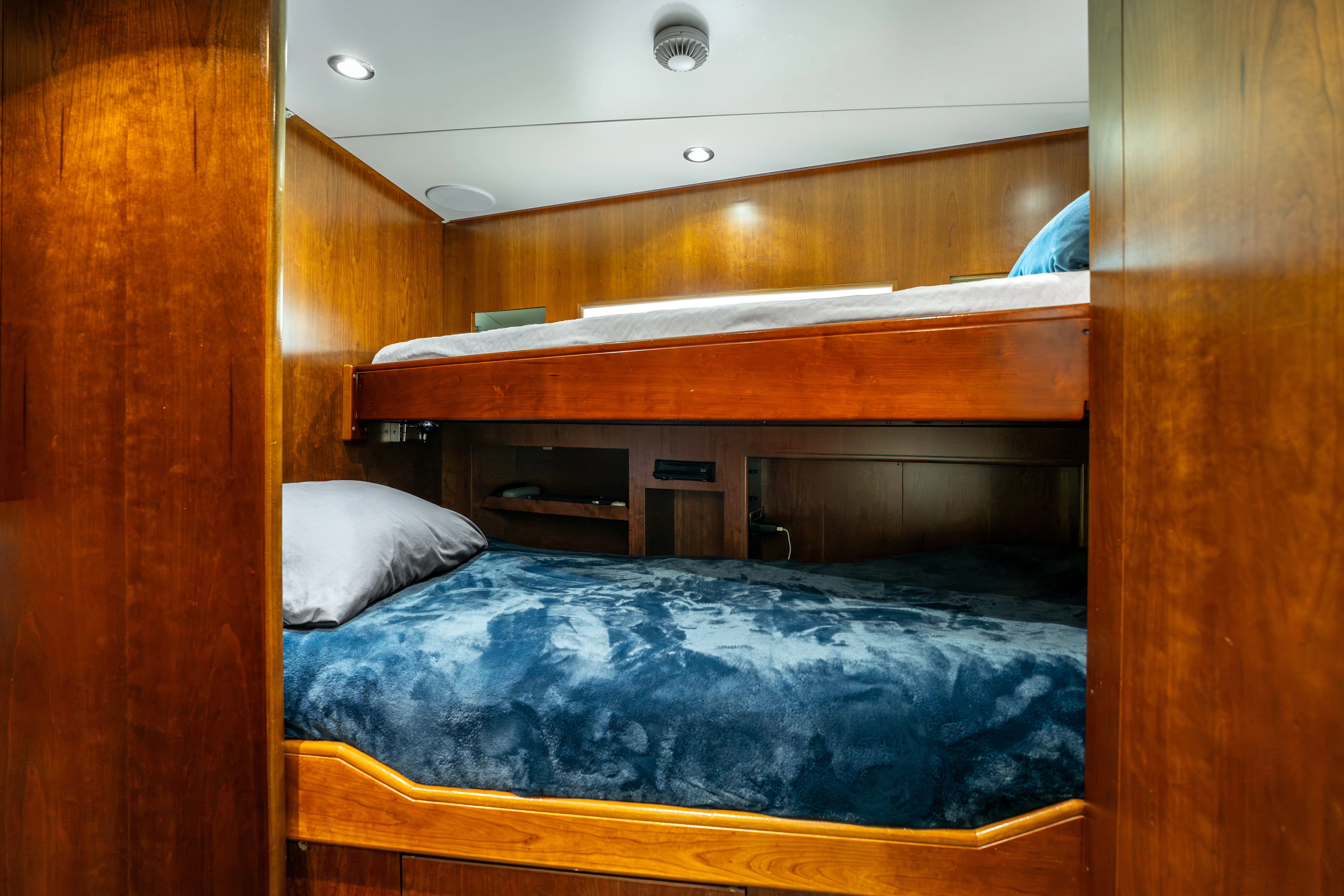 a bed with a blue sheet aboard ARTEMIS Yacht for Sale