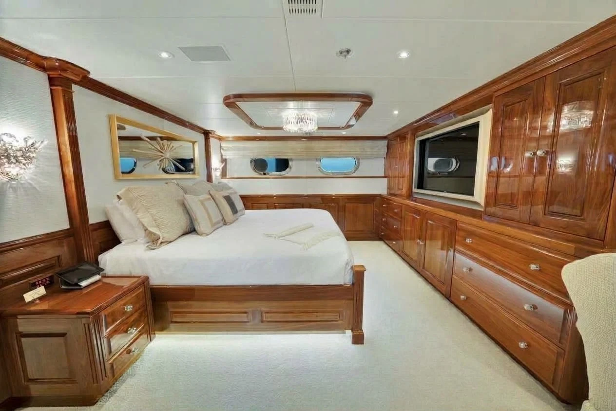 a bedroom with a bed and a dresser aboard SILVER LINING Yacht for Sale