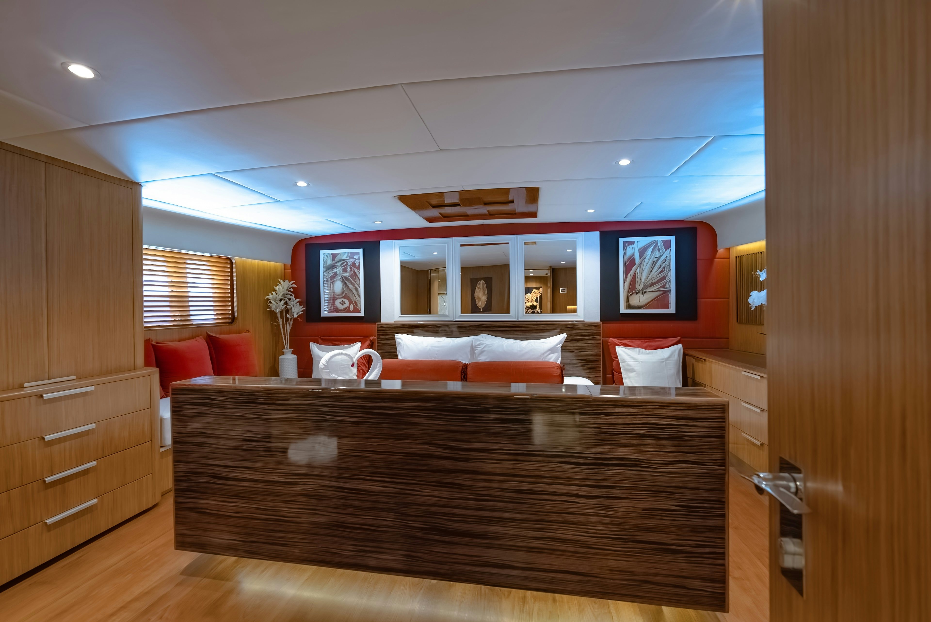 a room with a wood floor and a wood cabinet and a red couch aboard THEA Yacht for Sale