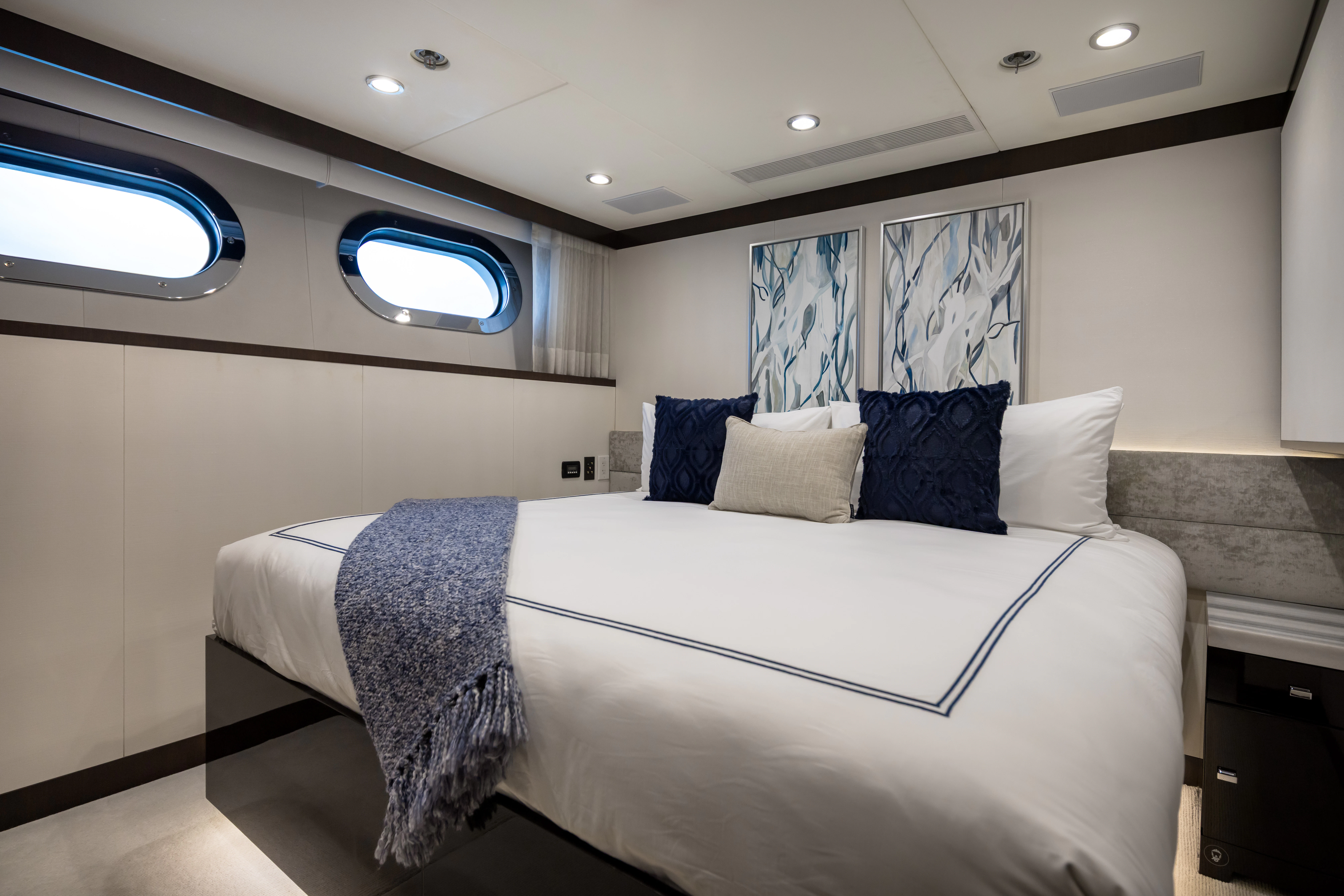 a bed with blue pillows aboard MISS MICHELLE Yacht for Charter