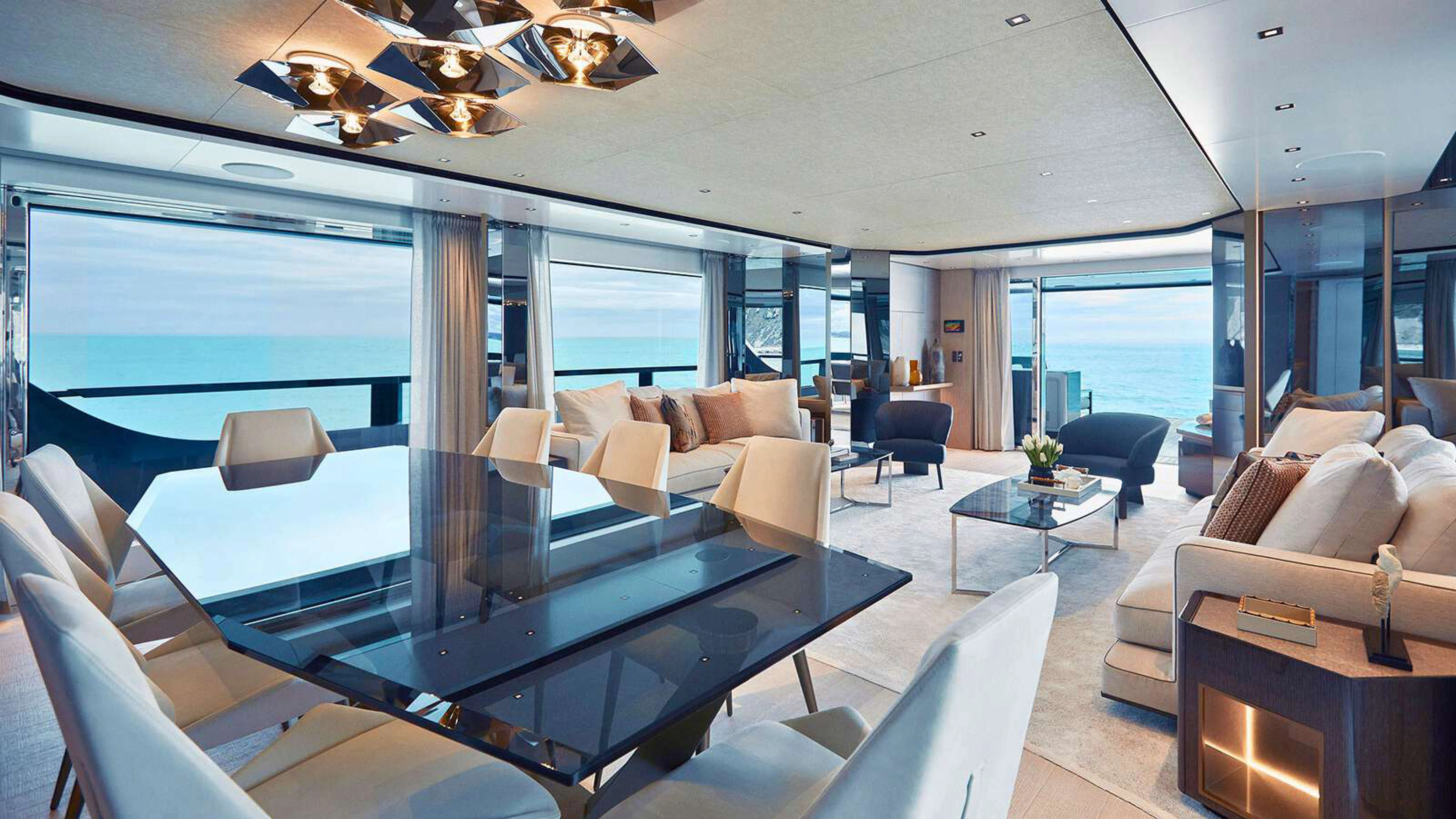 a living room with a large glass table and a large window aboard PAZIENZA Yacht for Charter