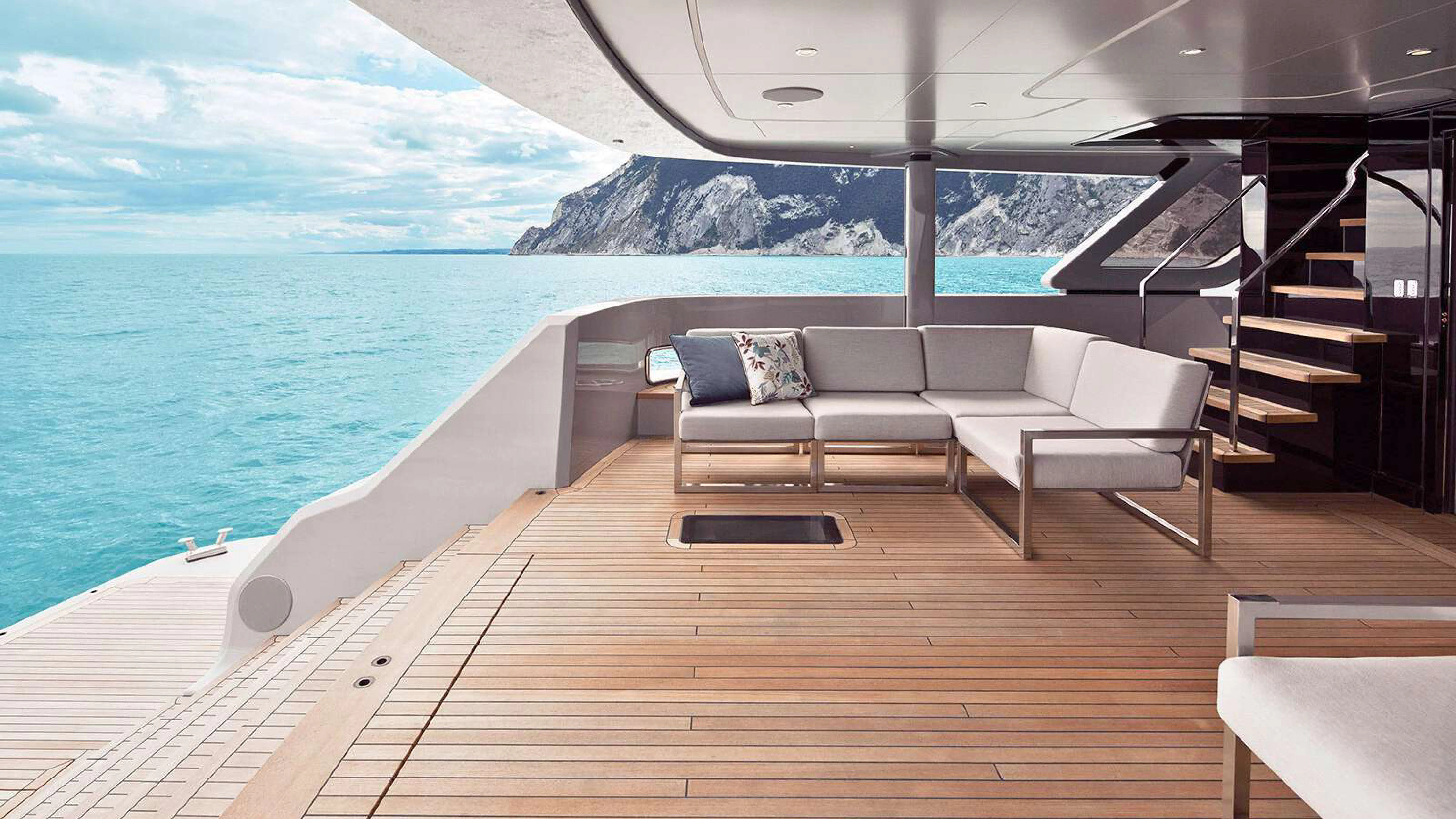 a deck with a view of the ocean and mountains aboard PAZIENZA Yacht for Charter