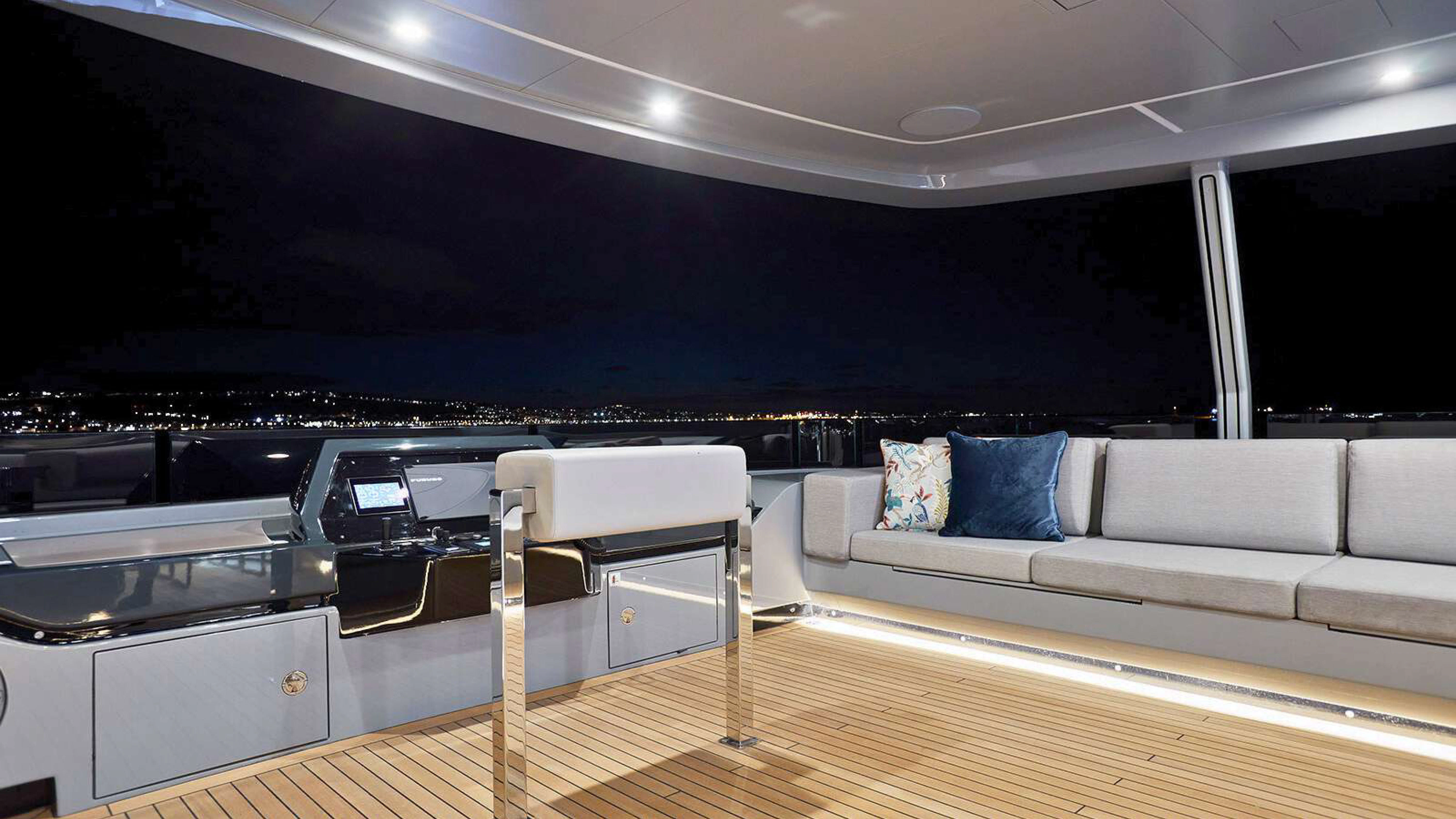a white couch and a white sofa in a room with a large window aboard PAZIENZA Yacht for Charter