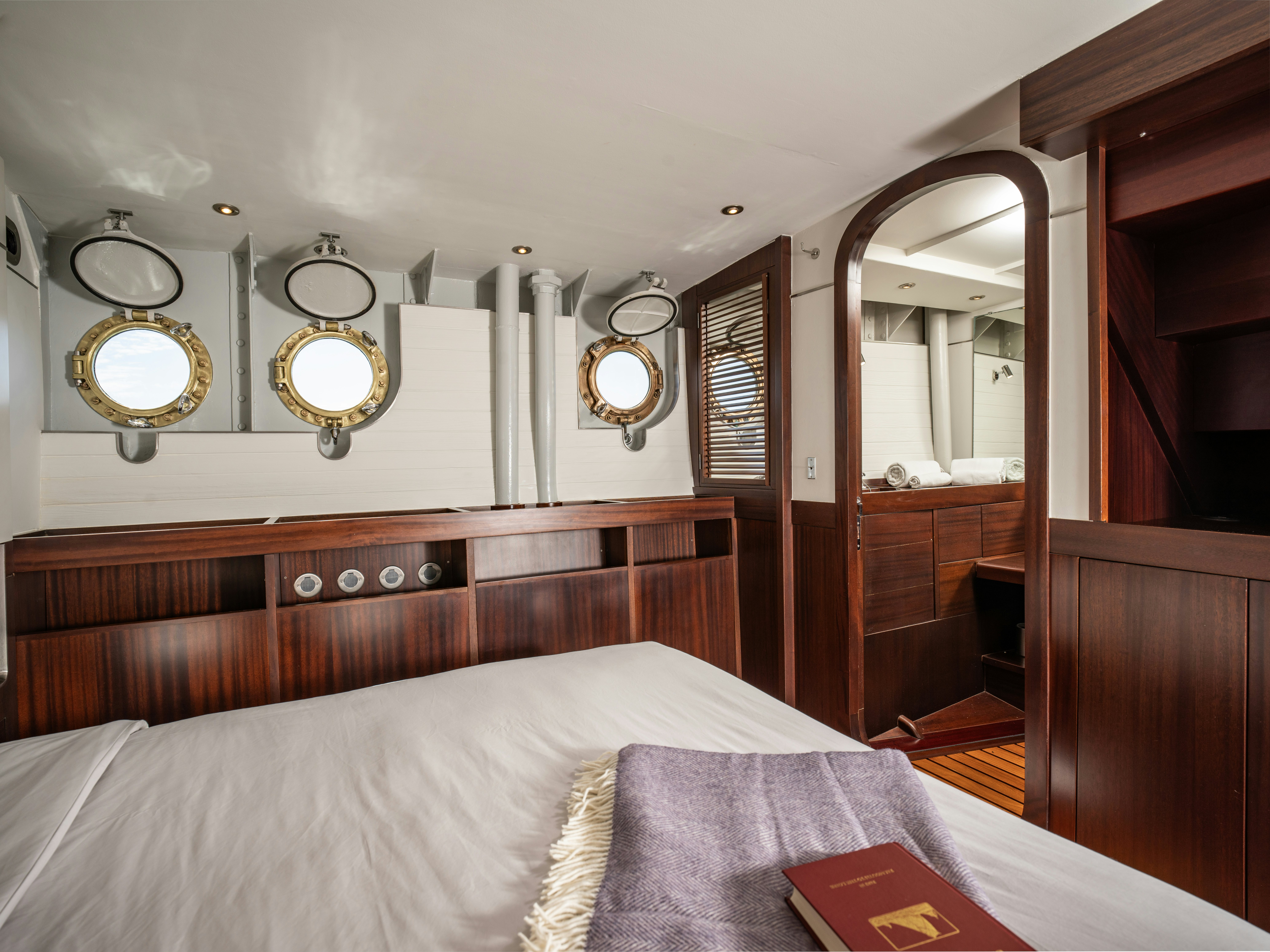 a bedroom with a bed and a mirror aboard LA FENICE Yacht for Sale