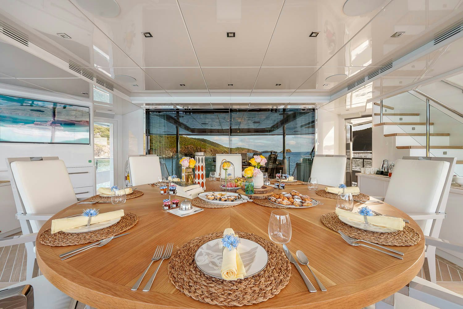 a dining table with plates and chairs aboard KING BABY Yacht for Charter