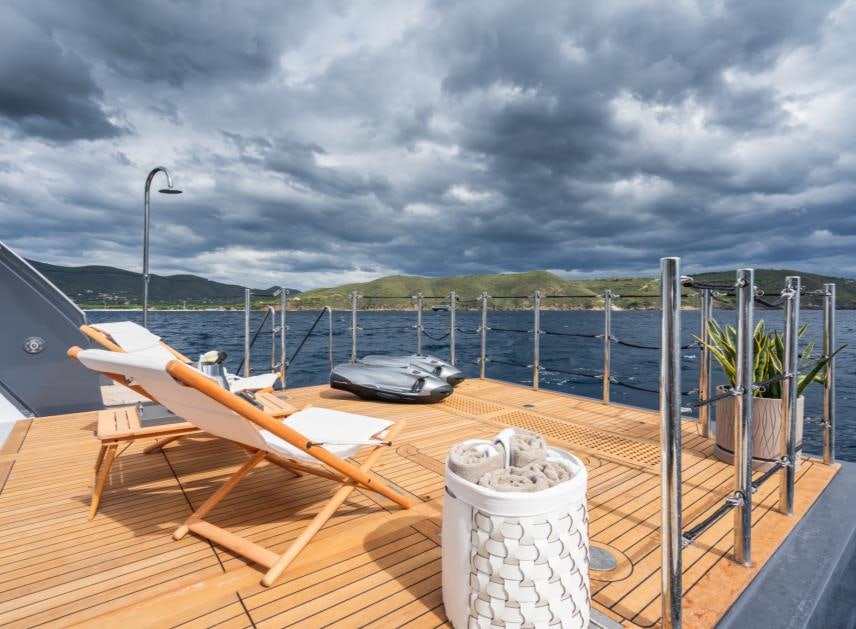 a deck with a drink and a laptop on it aboard M Yacht for Sale