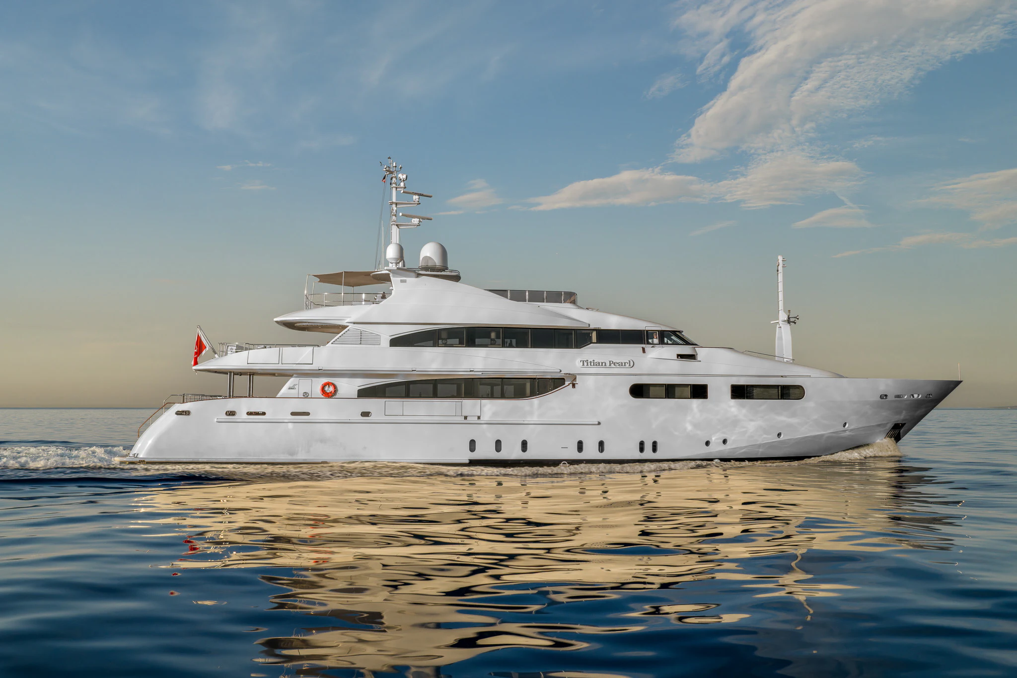 a white yacht on the water aboard TITIAN PEARL Yacht for Sale
