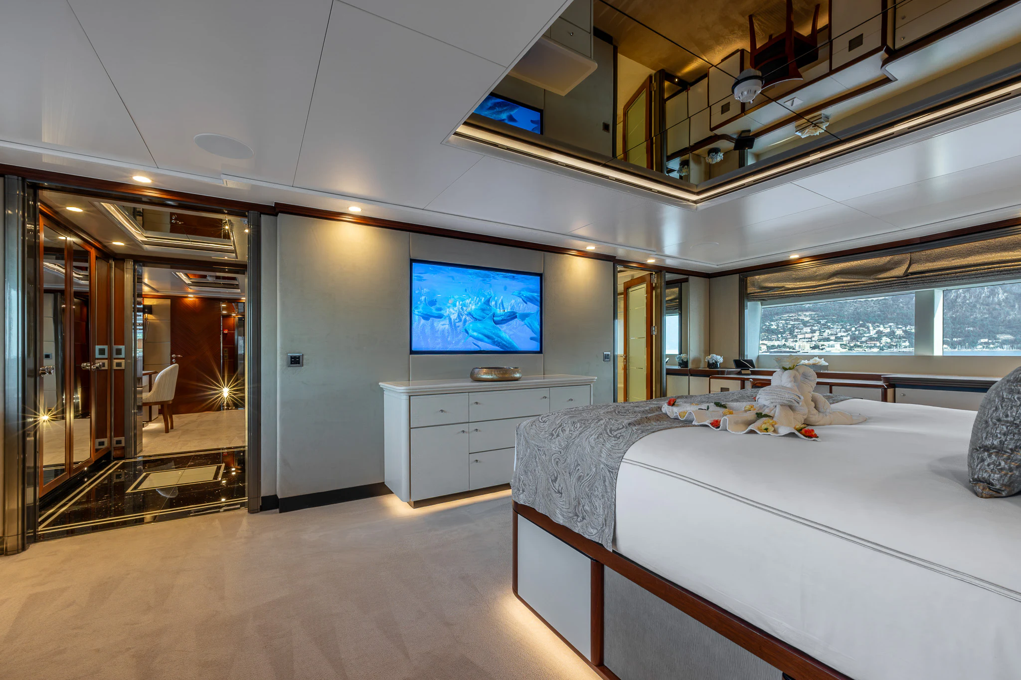 a room with a bed and a tv on the wall aboard TITIAN PEARL Yacht for Sale