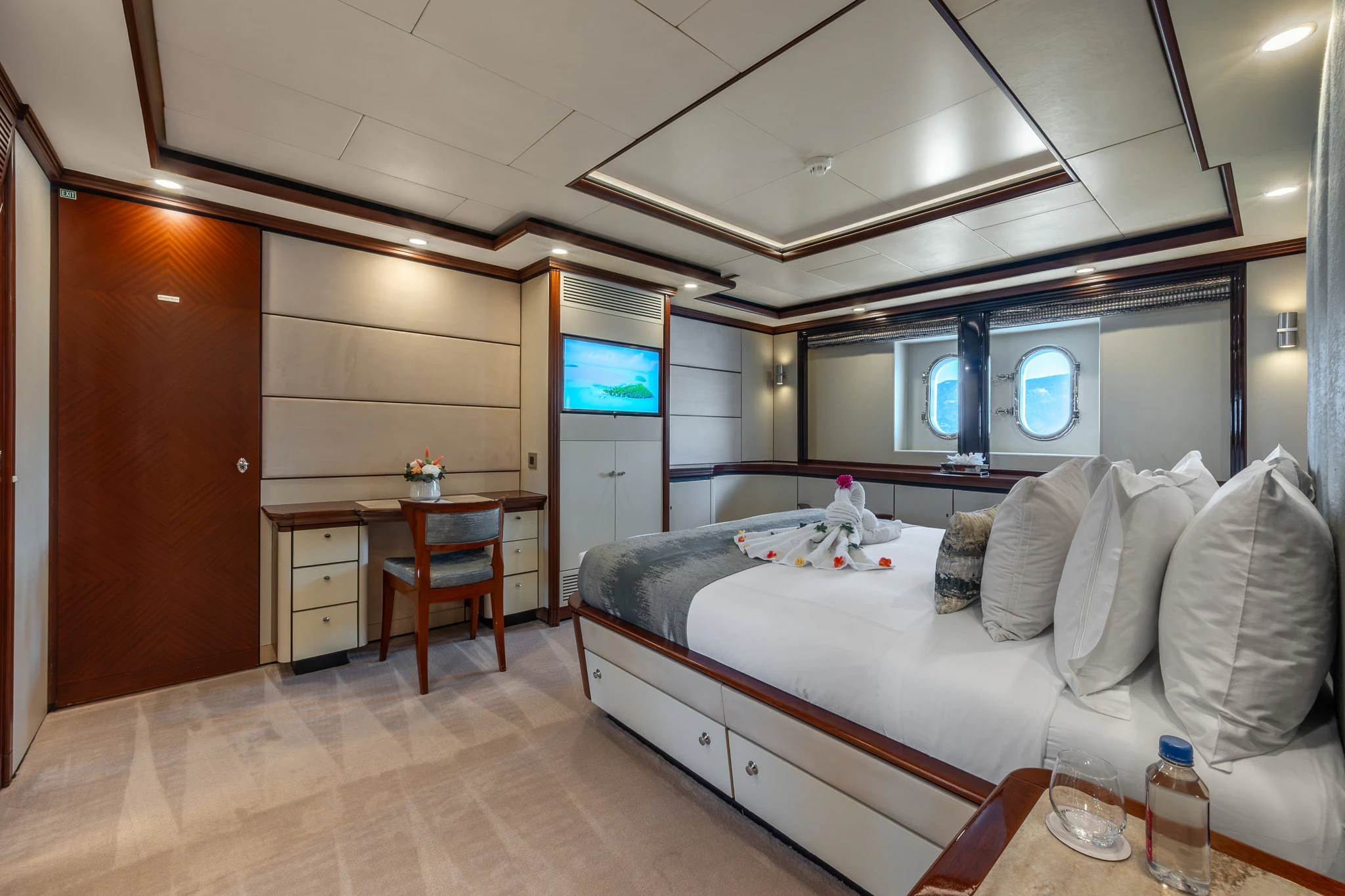 a room with a bed and a desk aboard TITIAN PEARL Yacht for Sale