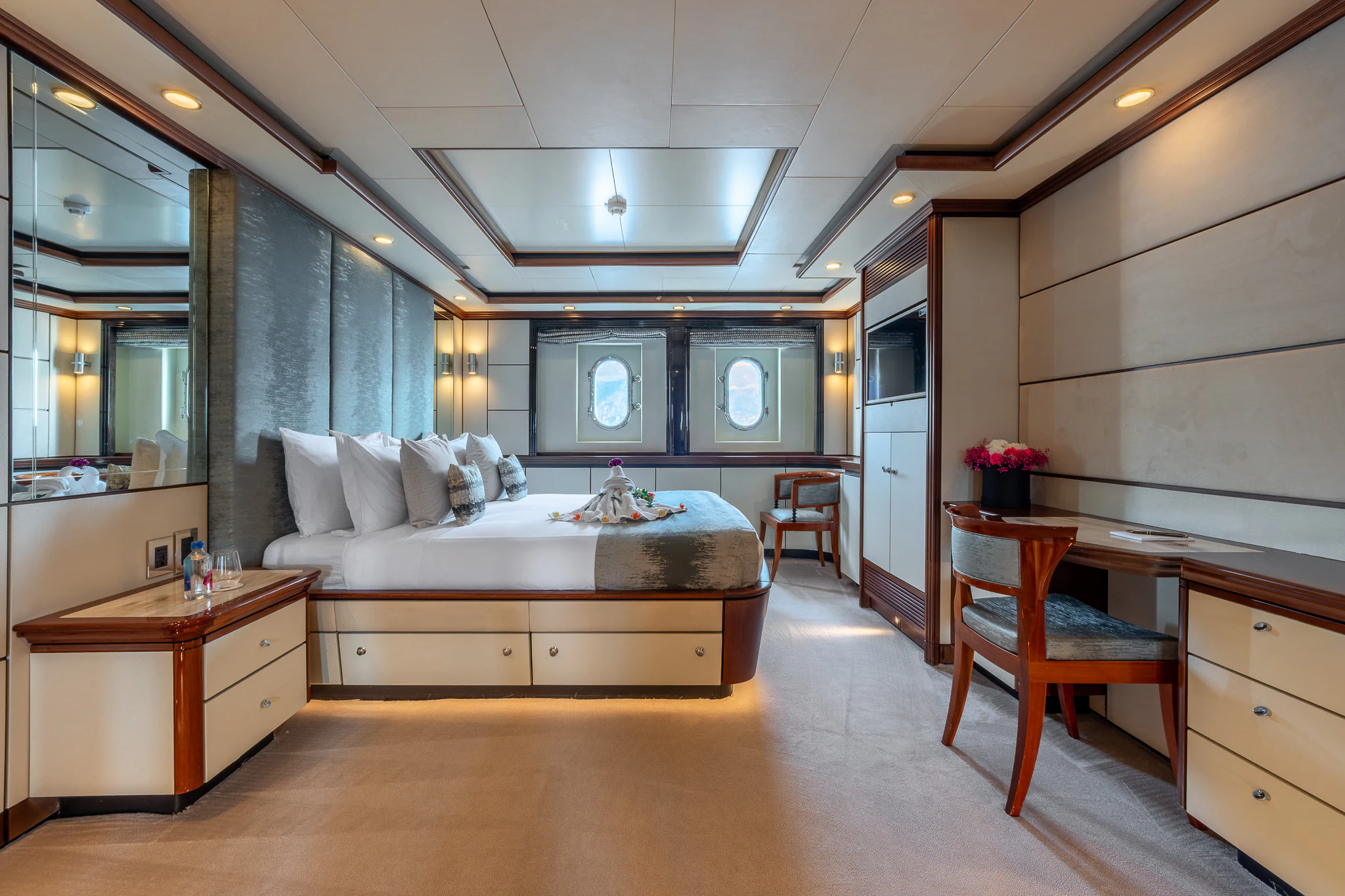 a large bedroom with a bed and desk aboard TITIAN PEARL Yacht for Sale