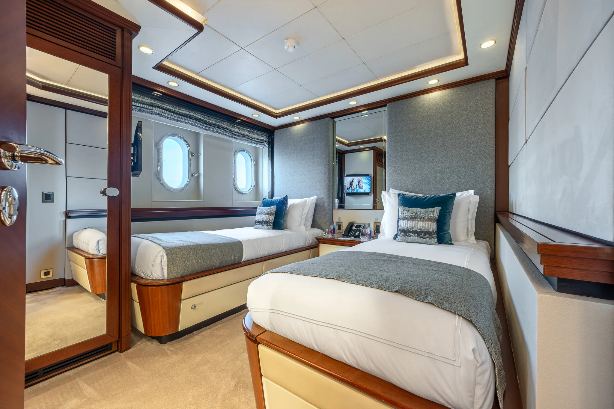 a room with a bed and a mirror aboard TITIAN PEARL Yacht for Sale
