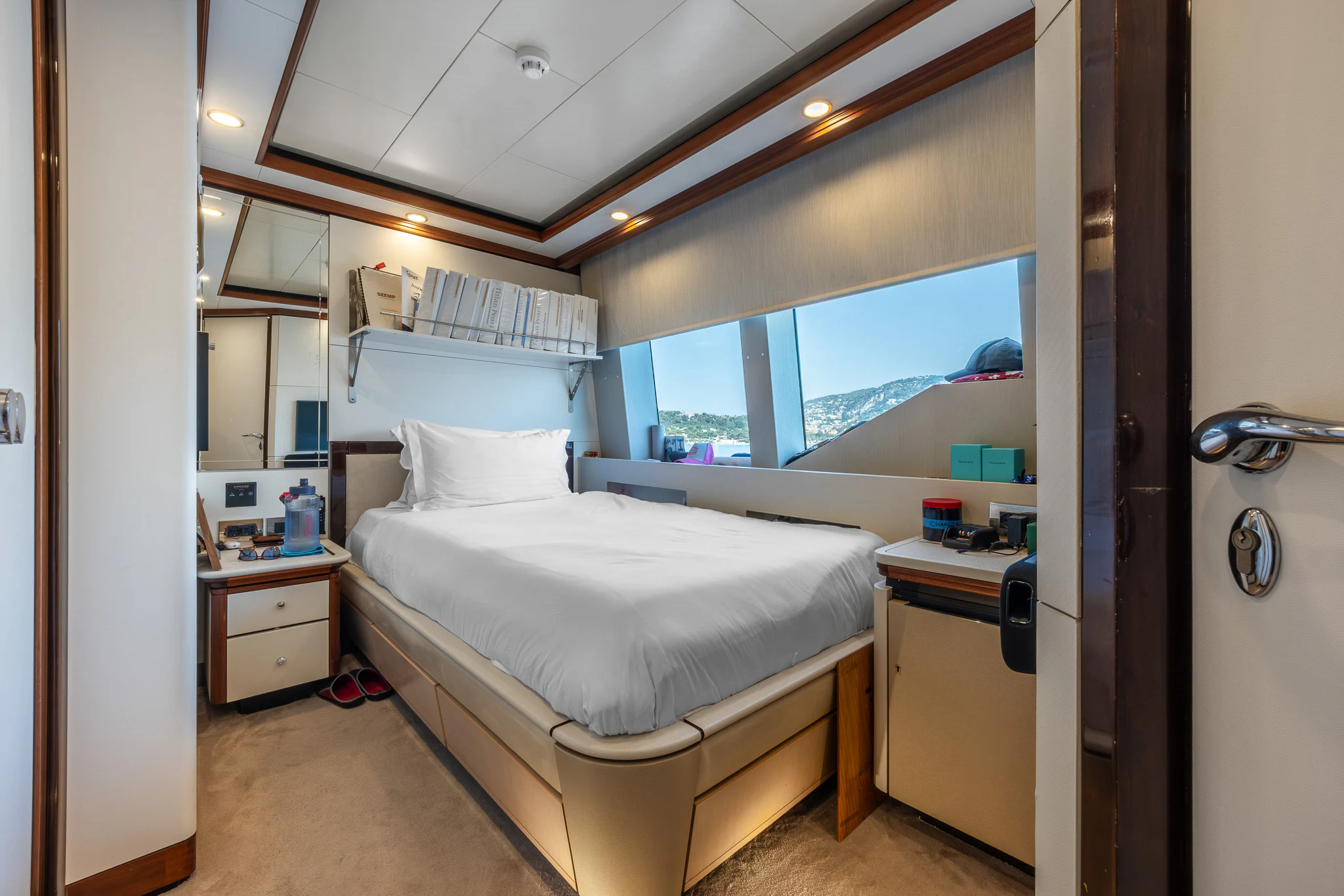 a room with a bed and a window aboard TITIAN PEARL Yacht for Sale
