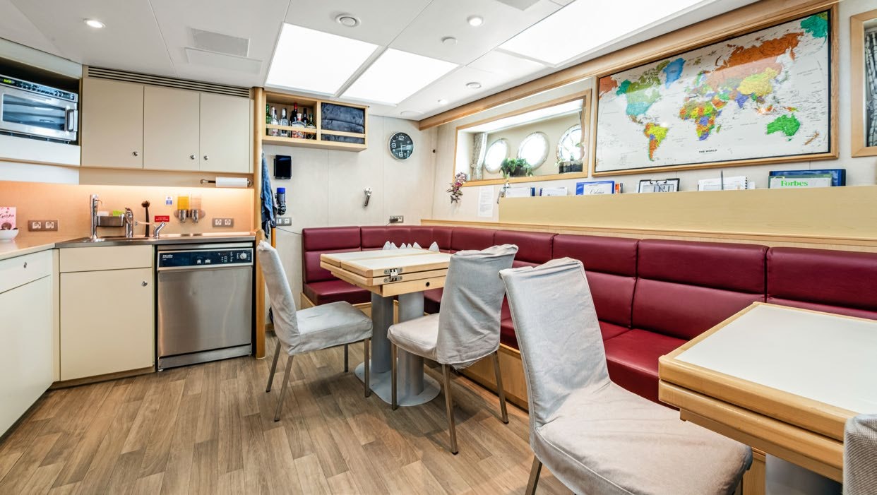 a kitchen with a pink table and chairs aboard CALYPSO Yacht for Sale