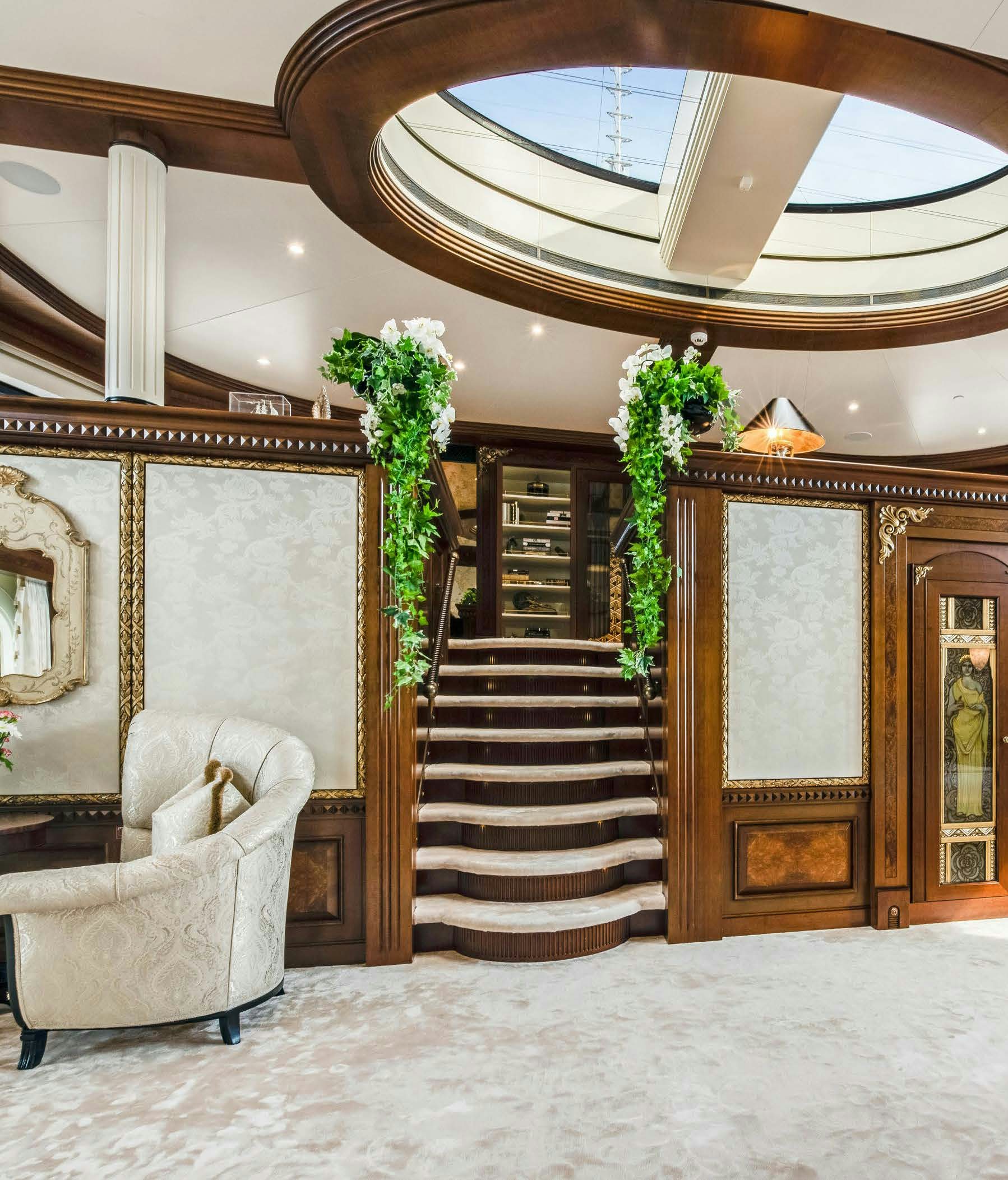 a large ornate stair case in a room with a chandelier aboard CALYPSO Yacht for Sale