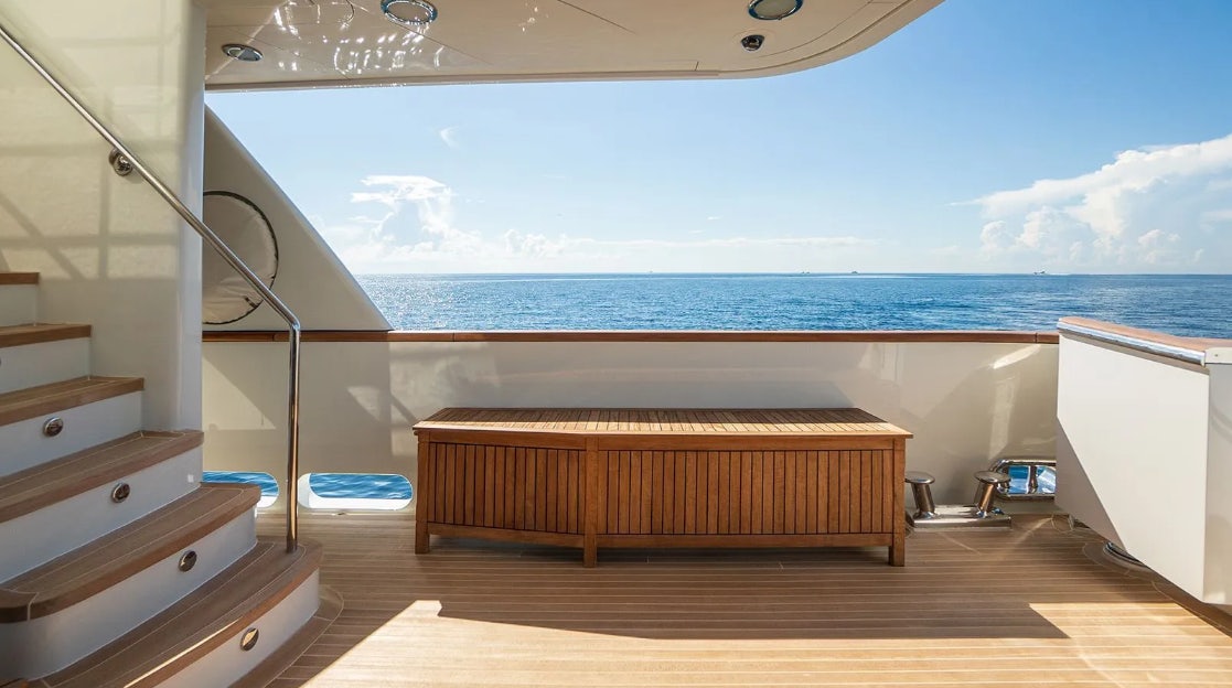 a wooden bench on a deck overlooking the ocean aboard CROSSED SABRE Yacht for Charter