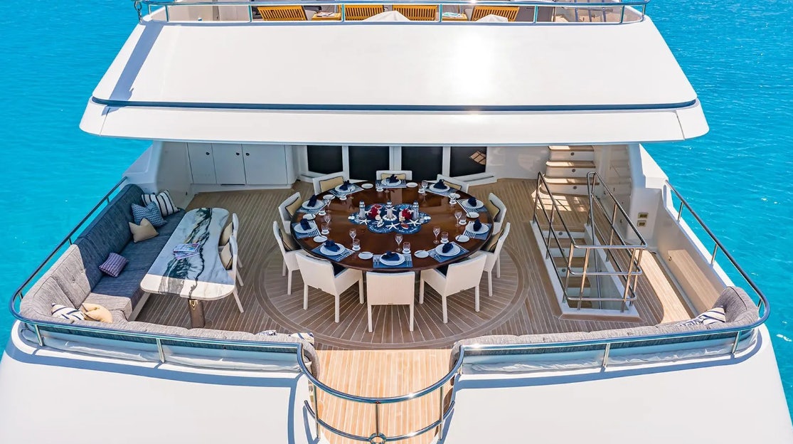 a boat with a table and chairs on the deck aboard CROSSED SABRE Yacht for Charter