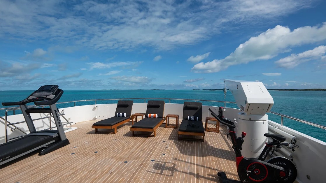 a deck with chairs and a table on it aboard CROSSED SABRE Yacht for Charter