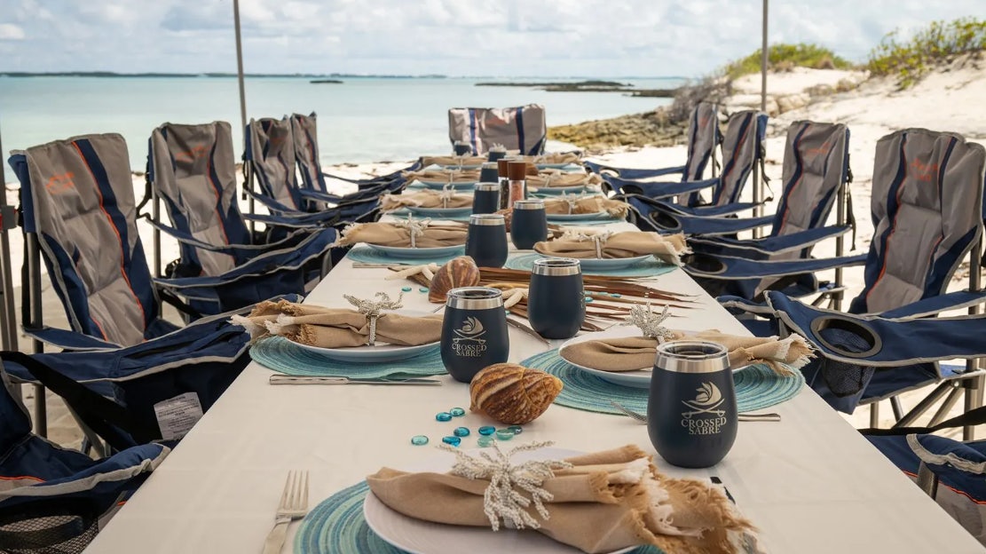 a table with chairs and a can on it aboard CROSSED SABRE Yacht for Charter