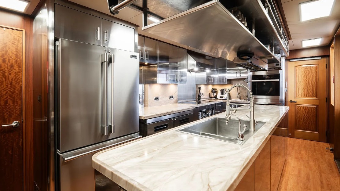 a kitchen with a stainless steel refrigerator aboard CROSSED SABRE Yacht for Charter