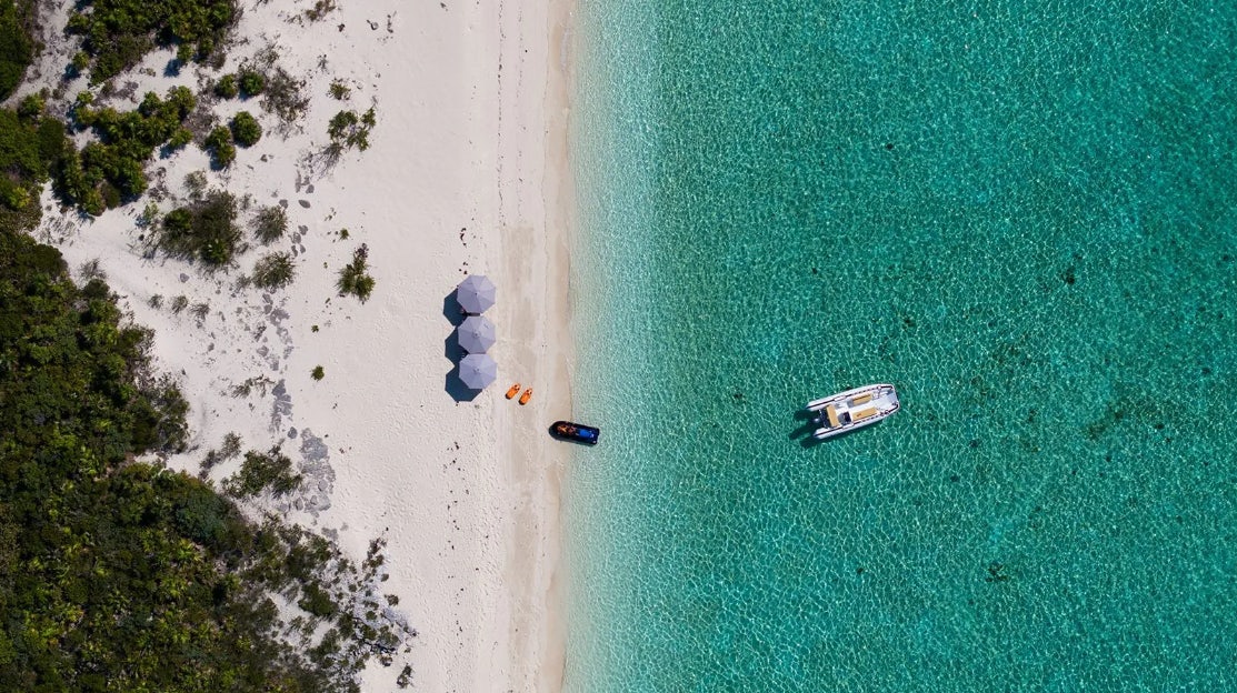 a group of people on a beach aboard CROSSED SABRE Yacht for Charter