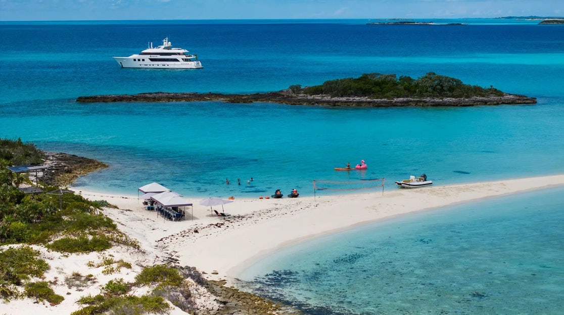 a beach with a boat and people in it aboard CROSSED SABRE Yacht for Charter