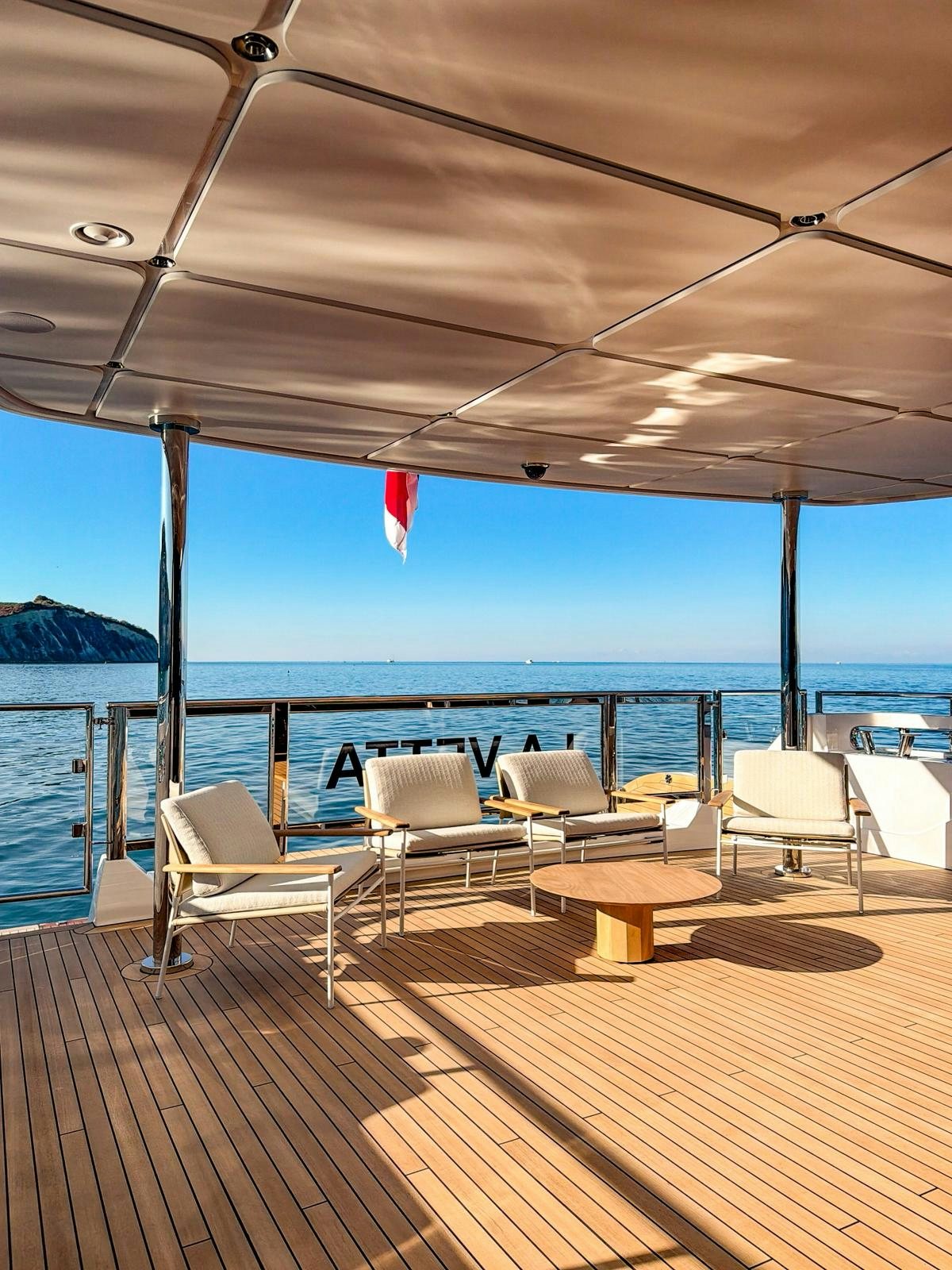 a deck with chairs and a body of water in the background aboard LA VETTA Yacht for Sale