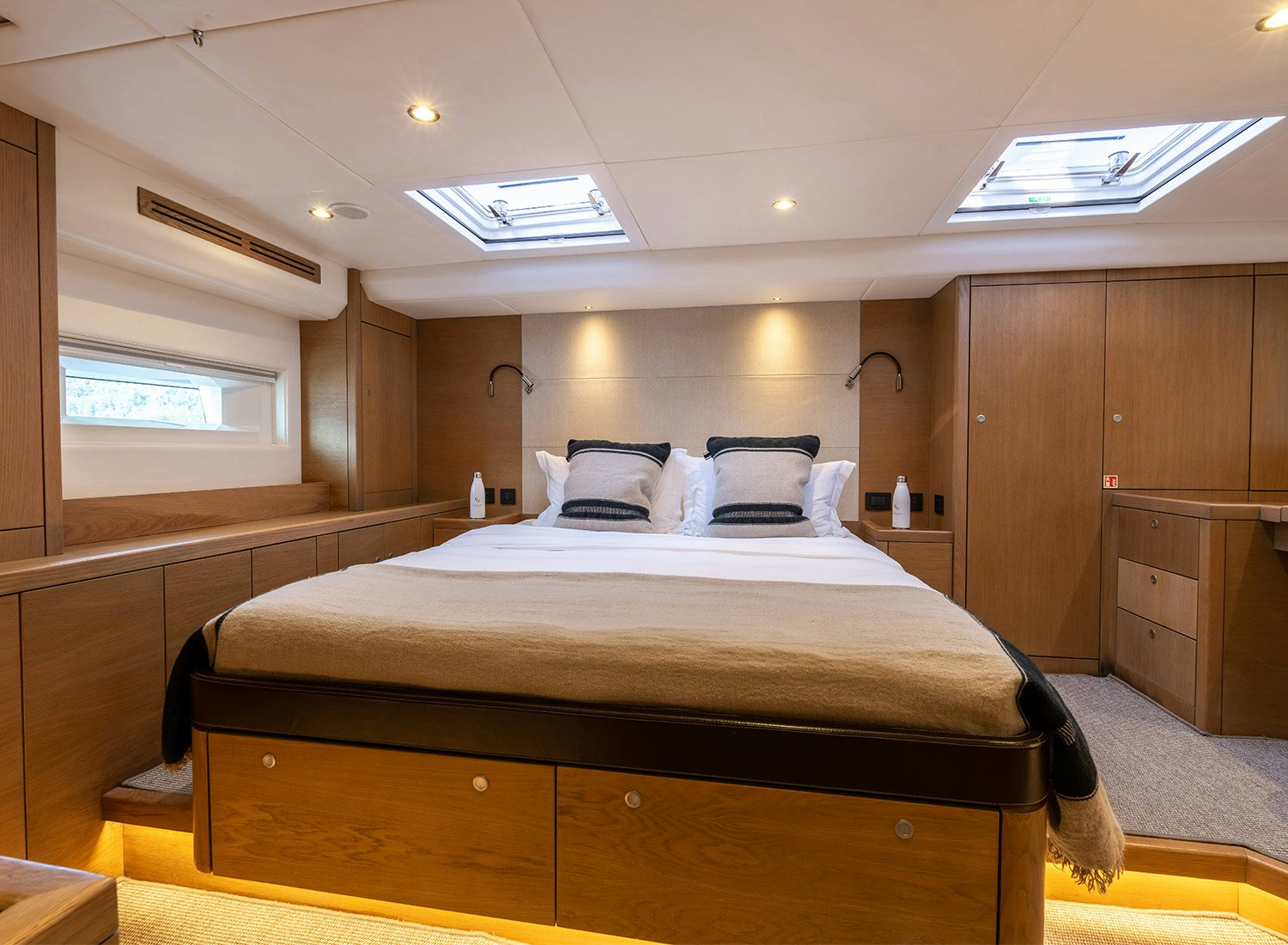 a bedroom with a bed and a wood cabinet aboard CHAMPAGNE HIPPY Yacht for Sale