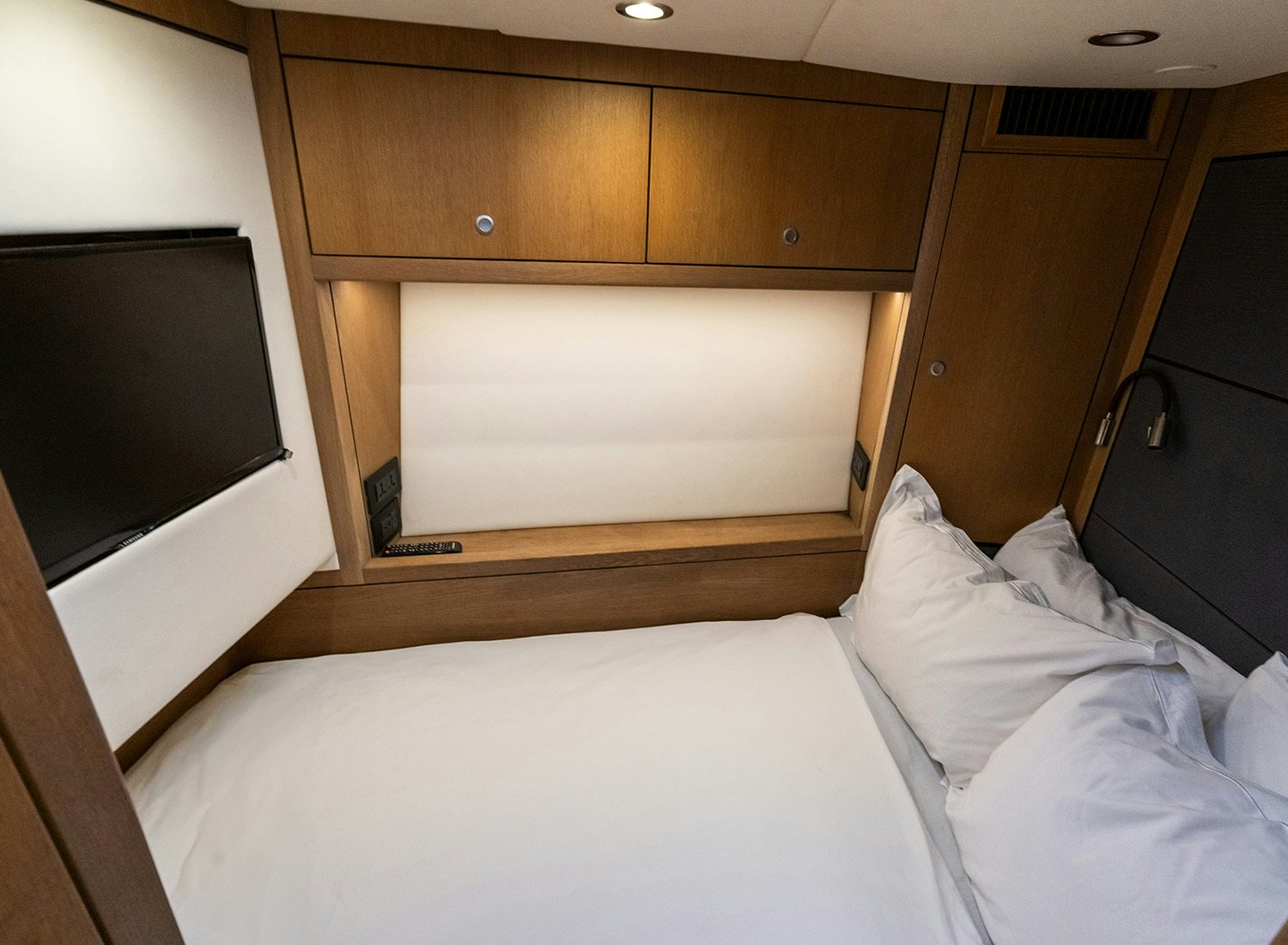 a bed with a television on the wall aboard CHAMPAGNE HIPPY Yacht for Sale
