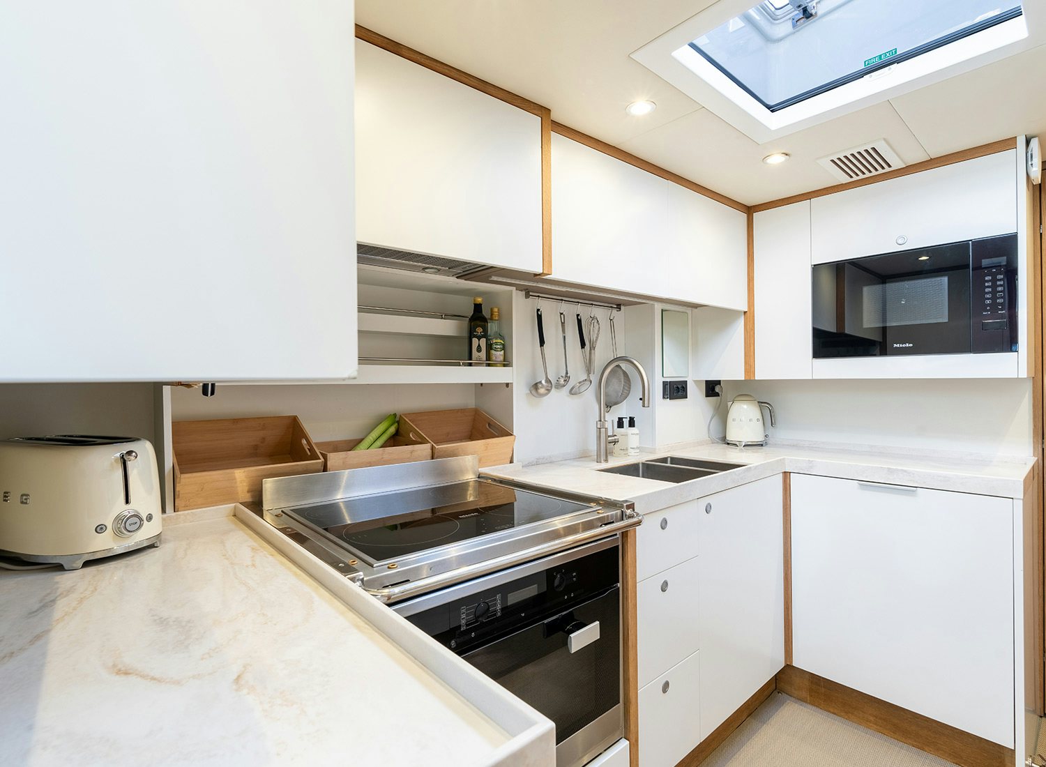 a kitchen with white cabinets aboard CHAMPAGNE HIPPY Yacht for Sale