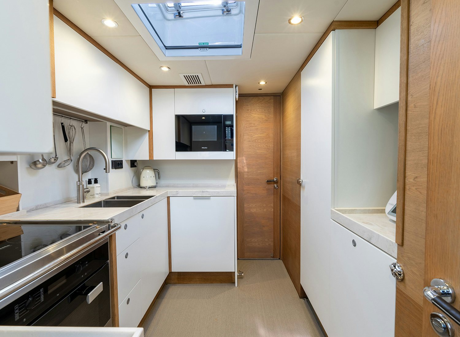 a kitchen with white cabinets aboard CHAMPAGNE HIPPY Yacht for Sale