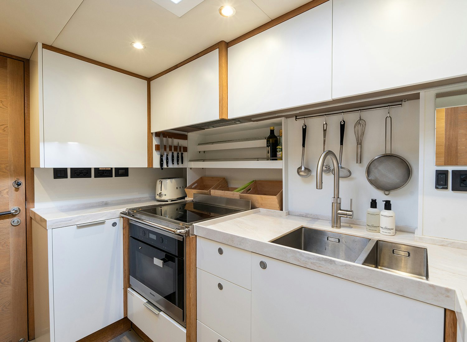 a kitchen with white cabinets aboard CHAMPAGNE HIPPY Yacht for Sale