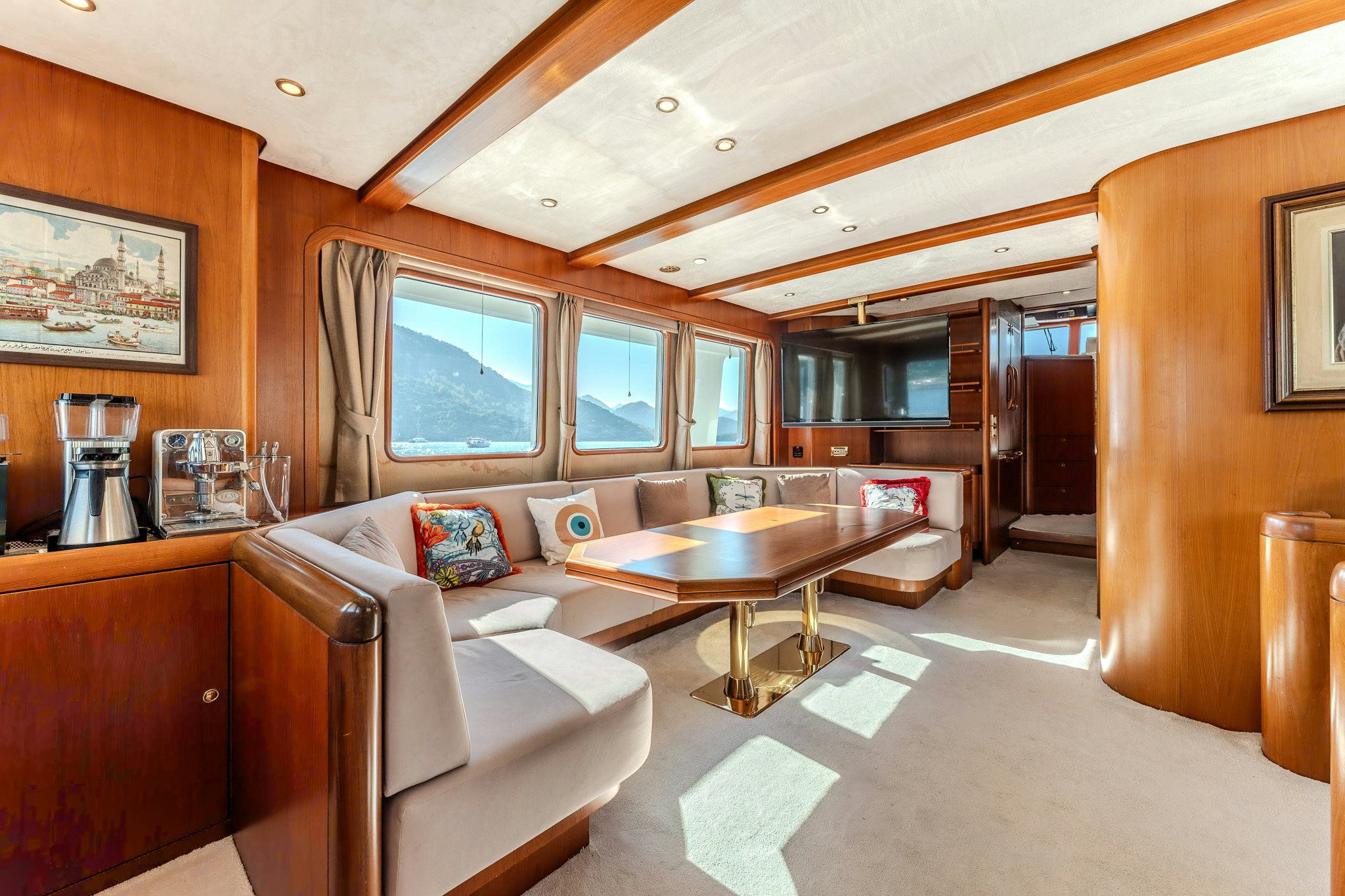 a living room with a table and couches aboard YOSMA Yacht for Sale
