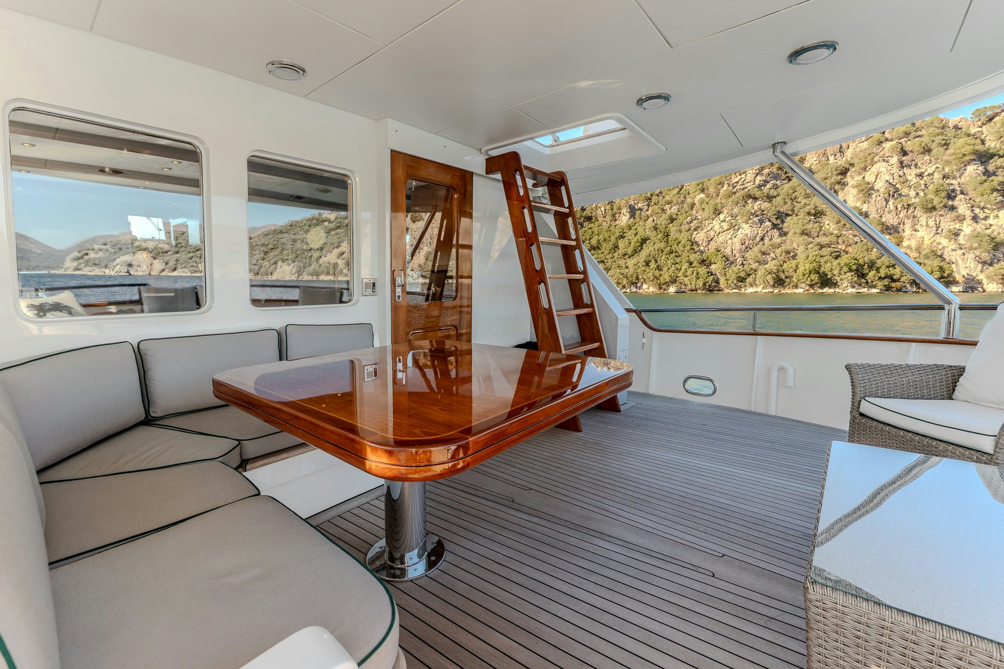 a living room with a table and couches aboard YOSMA Yacht for Sale