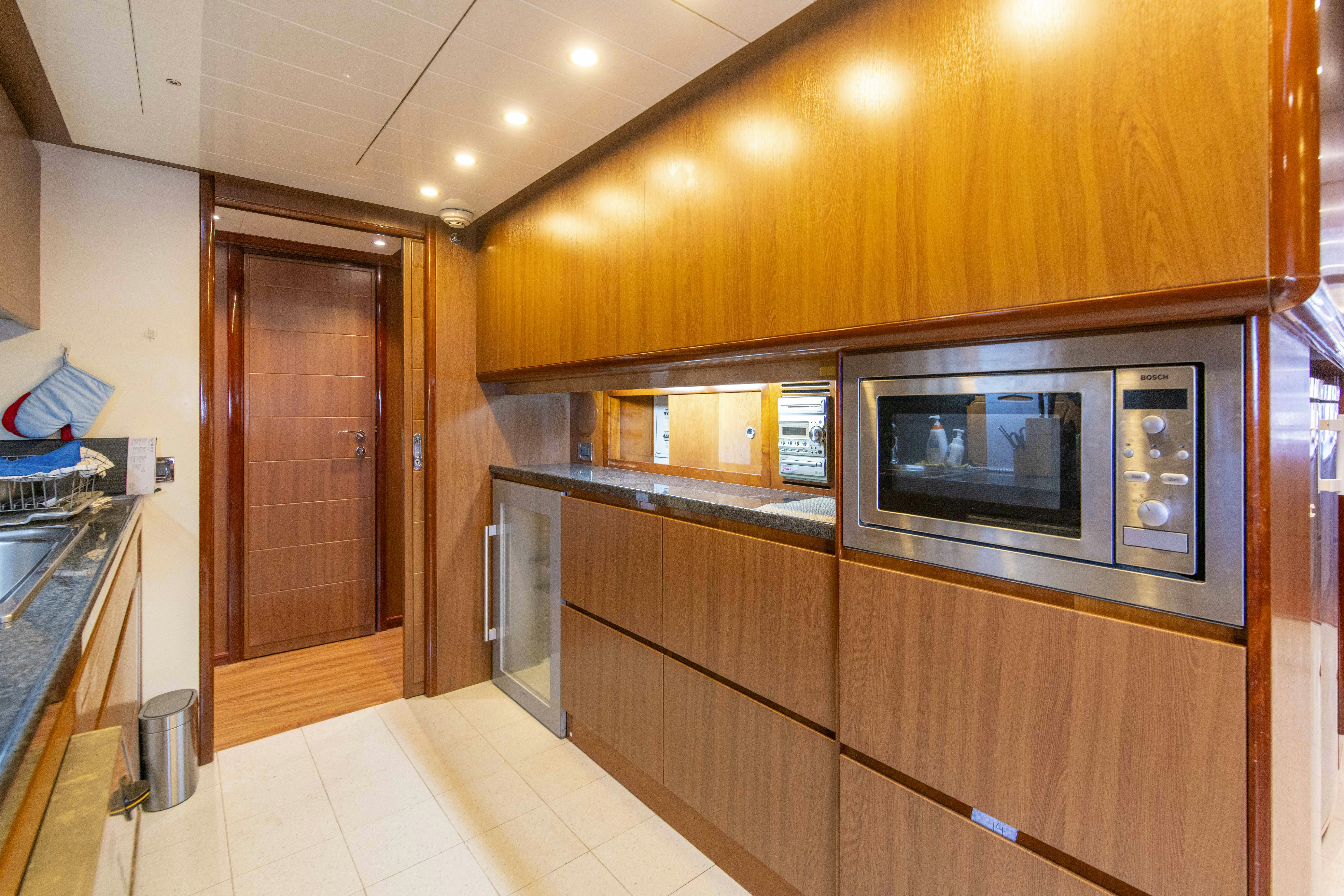 a kitchen with wooden cabinets aboard PANDORA Yacht for Sale