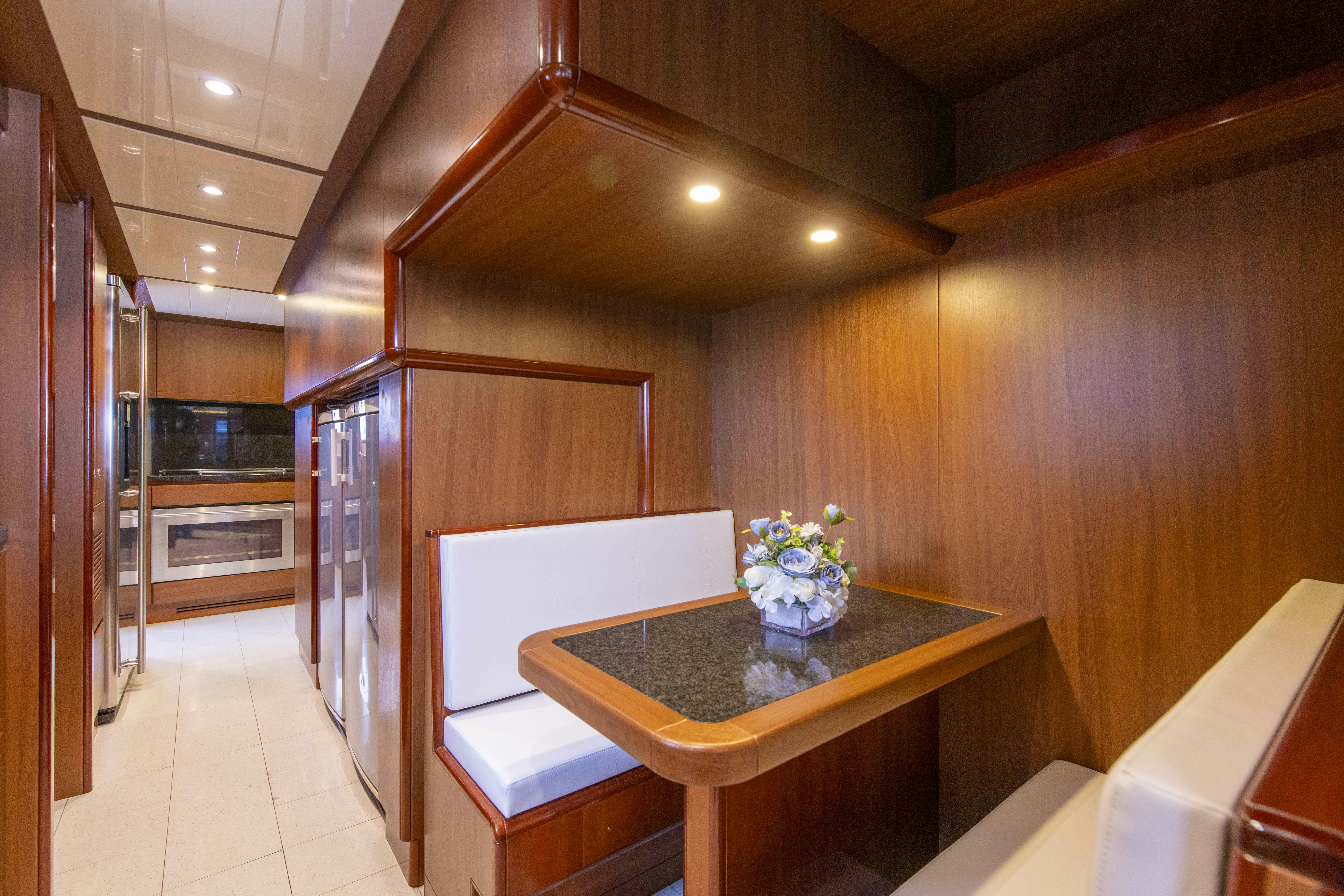 a kitchen with a table and chairs aboard PANDORA Yacht for Sale