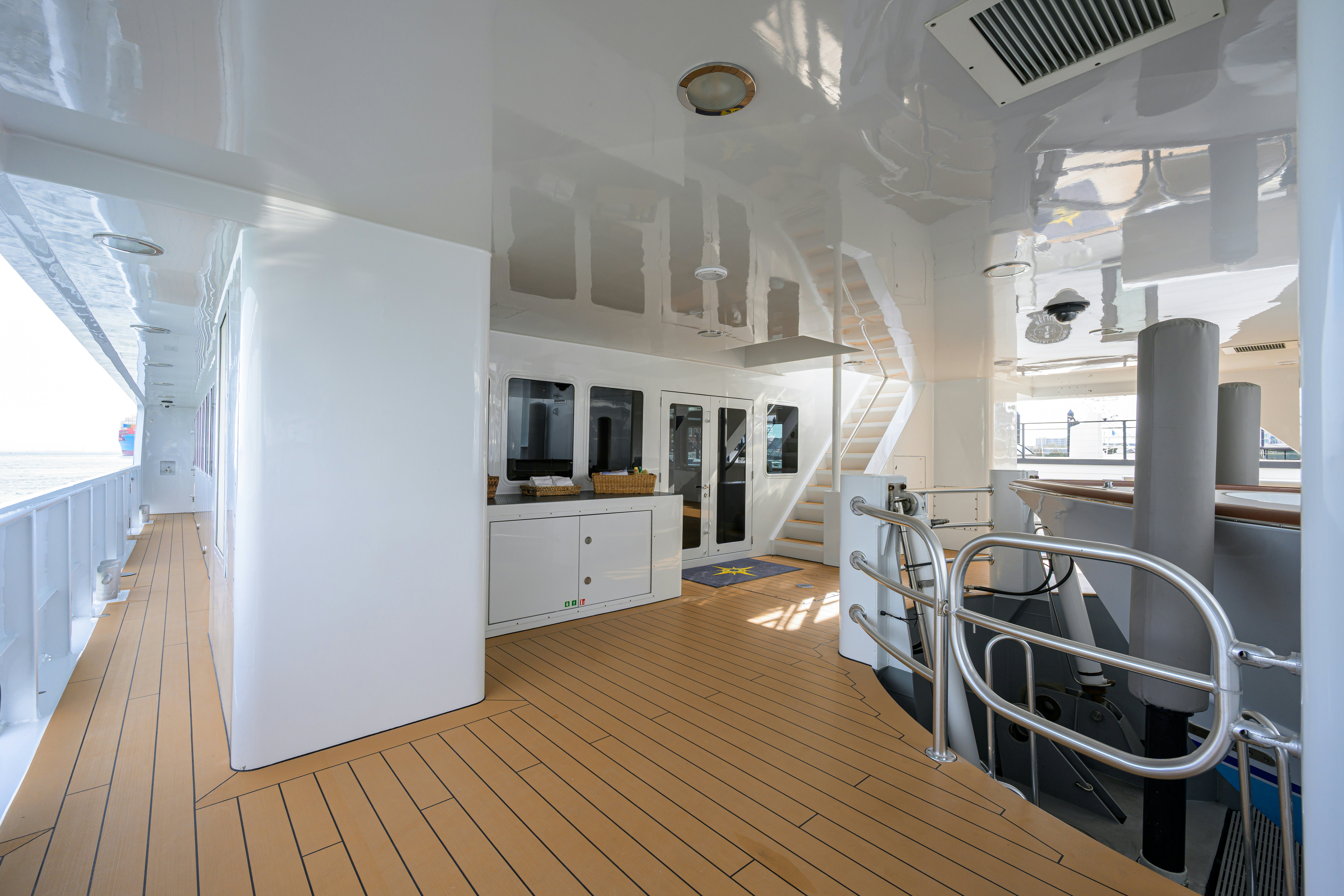 a room with a wood floor and white cabinets and a white wall aboard COMPASS ROSE Yacht for Sale
