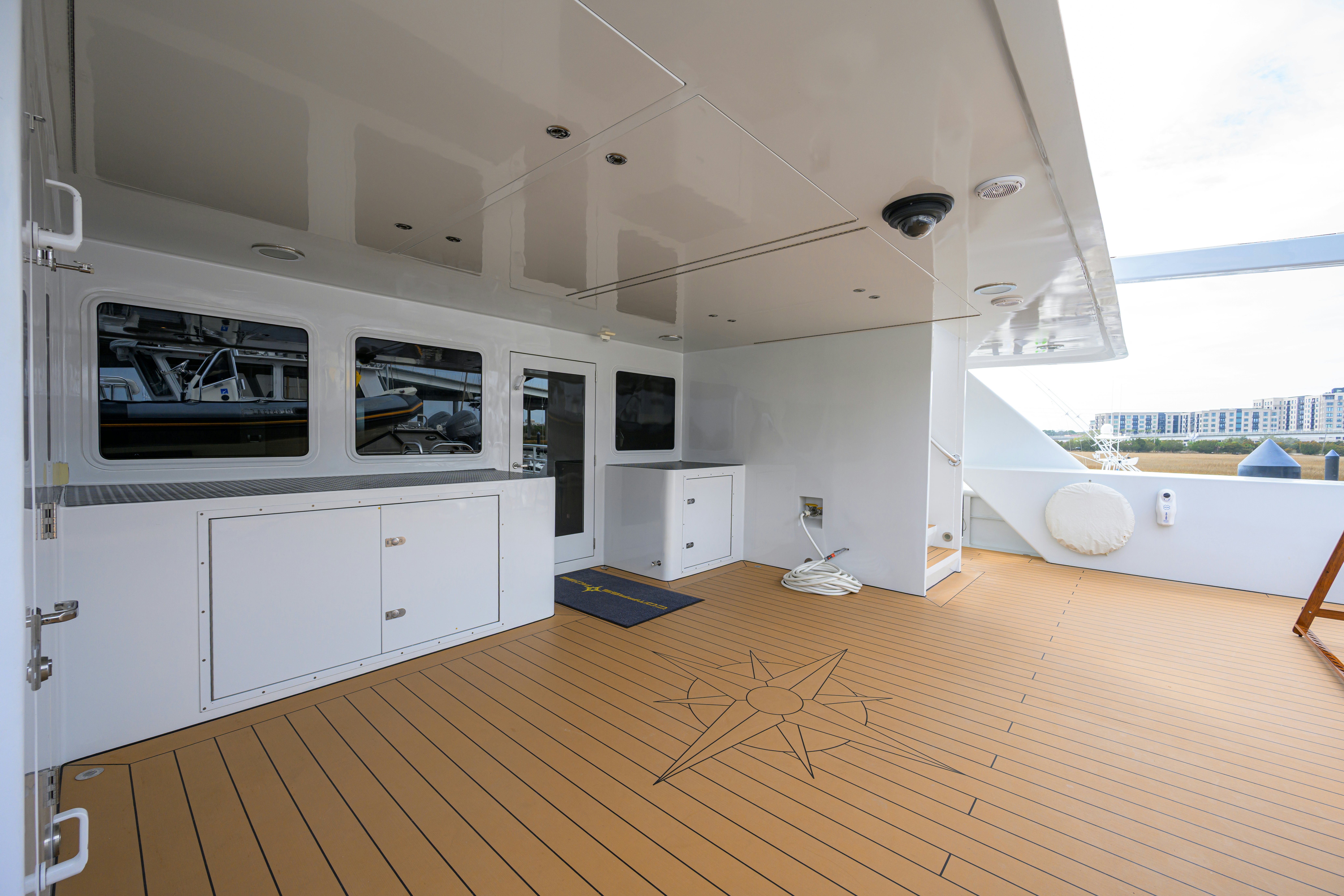a room with a wood floor and white cabinets and a window aboard COMPASS ROSE Yacht for Sale
