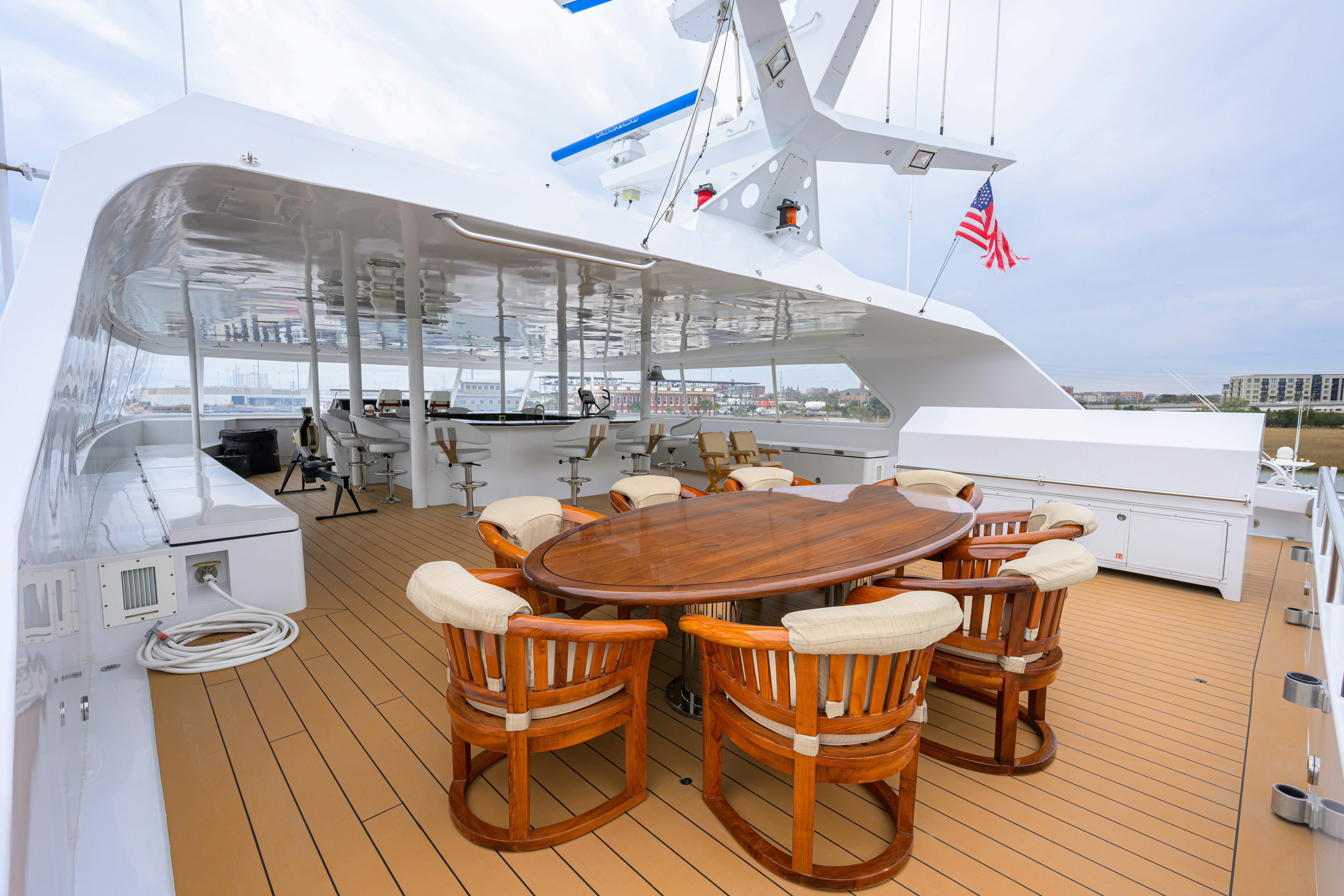 a deck with a table and chairs on it aboard COMPASS ROSE Yacht for Sale