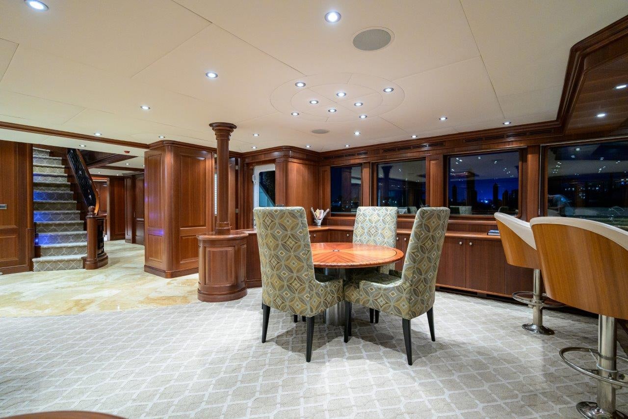 a room with a table and chairs aboard COMPASS ROSE Yacht for Sale