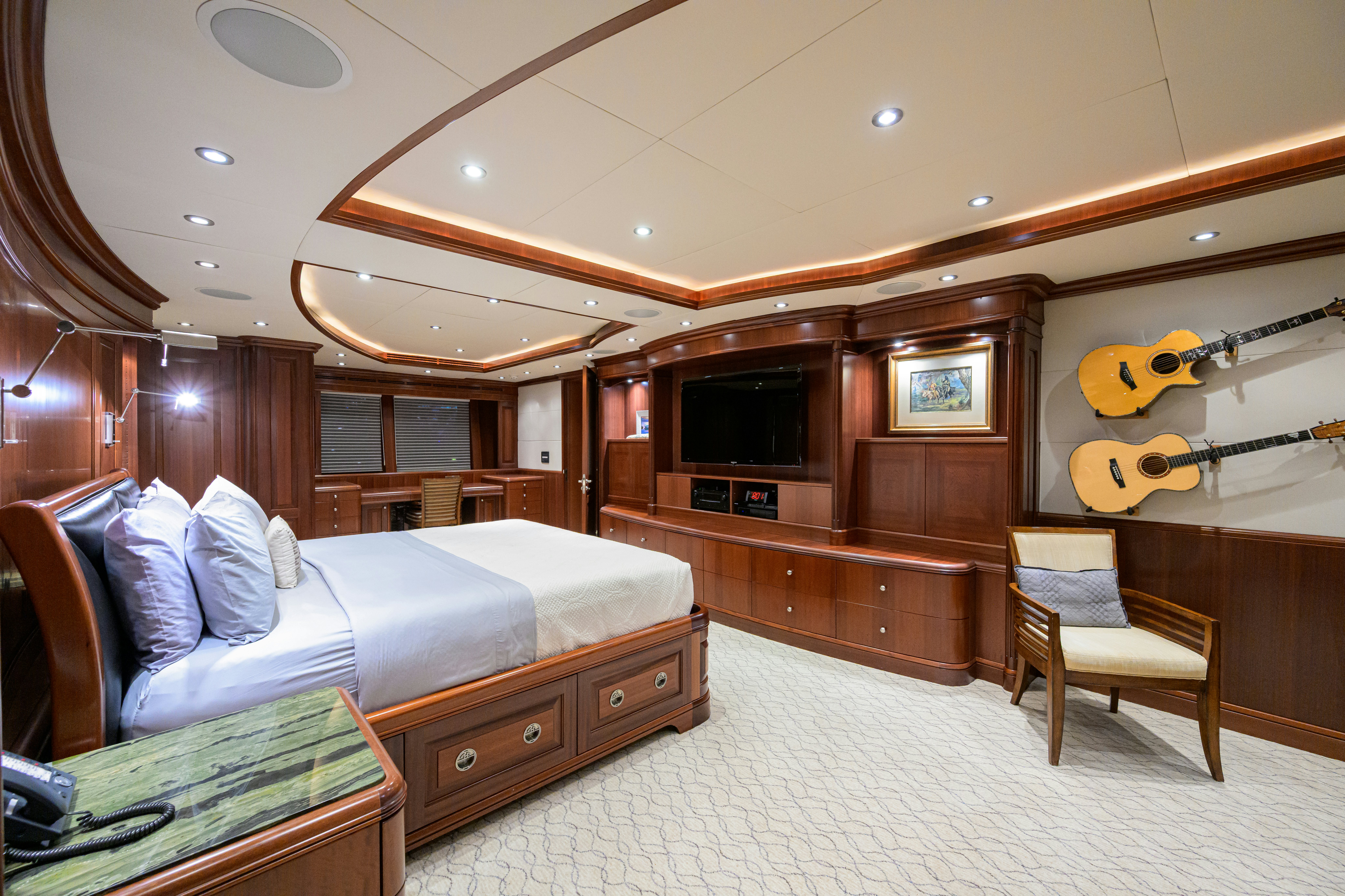 a bedroom with a bed and a television aboard COMPASS ROSE Yacht for Sale
